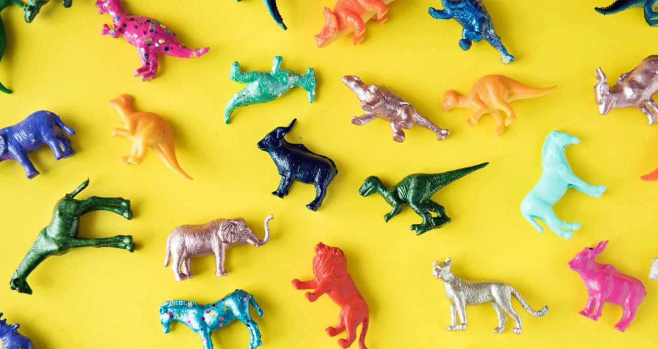 A Vibrant Display Of Inclusive Zoo Animal Toys Gathered On A Small Wooden Table. Background