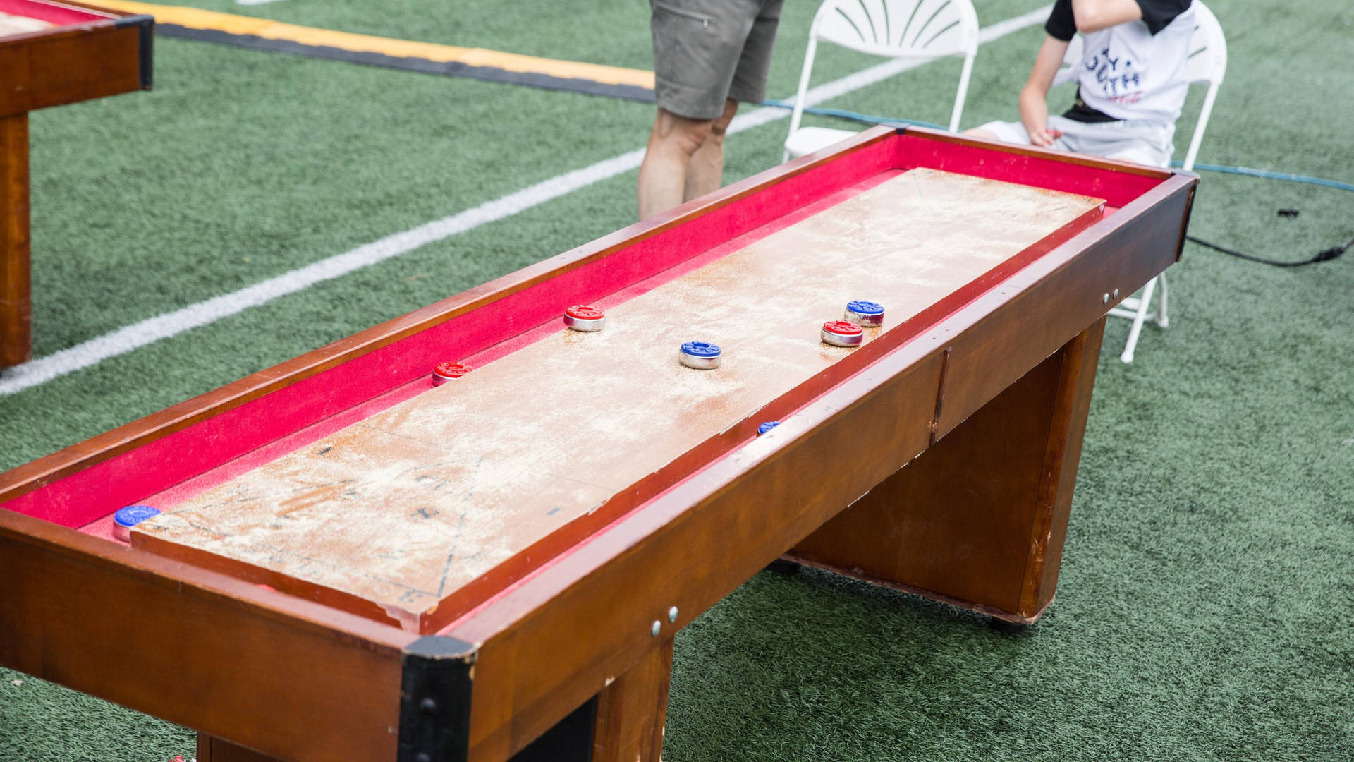 A Vibrant Indoor Shuffleboard Game In Action Background