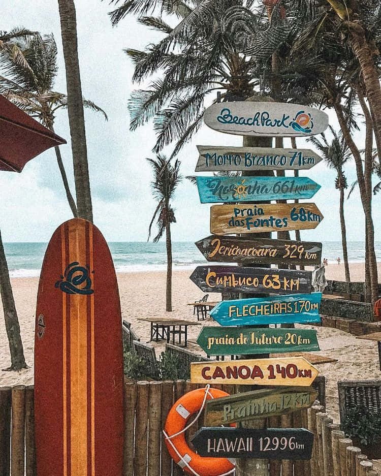 A Vibrant Surfboard Leaning Against A Beach Sign Background