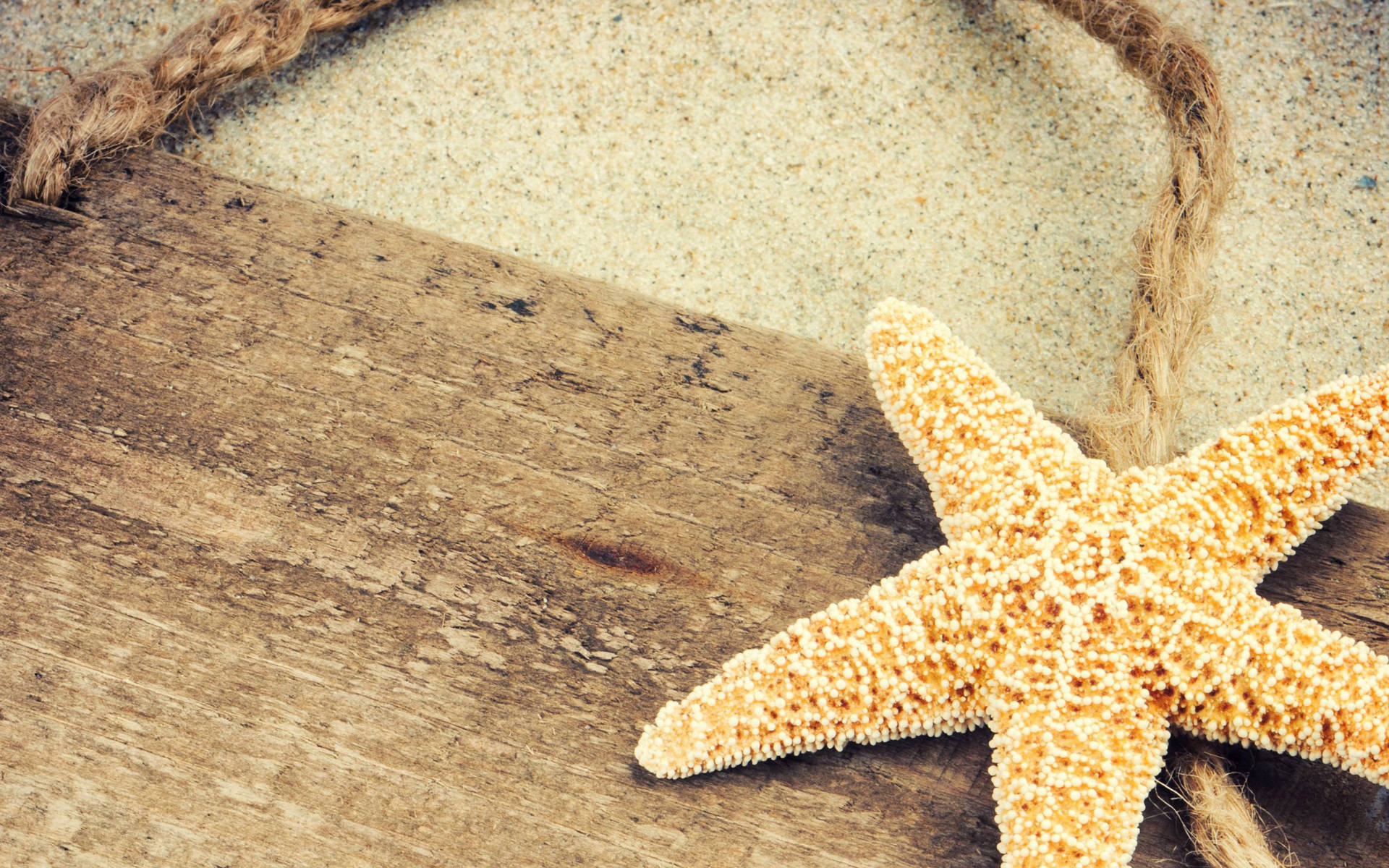 A Vibrant Yellow Starfish Resting On Wooden Surface Background