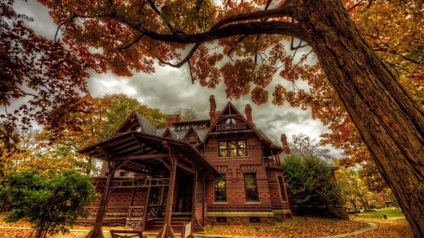 A Victorian House In The Fall With Leaves Background