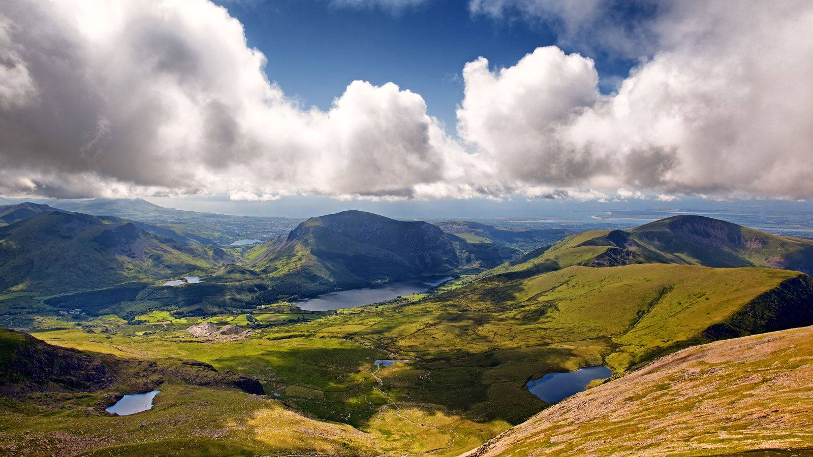 A View Of A Mountain Range With Clouds In The Sky