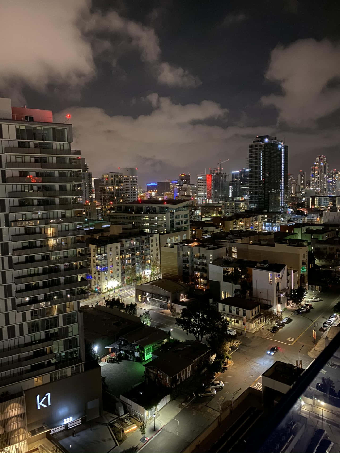 A View Of The City At Night From An Apartment Background