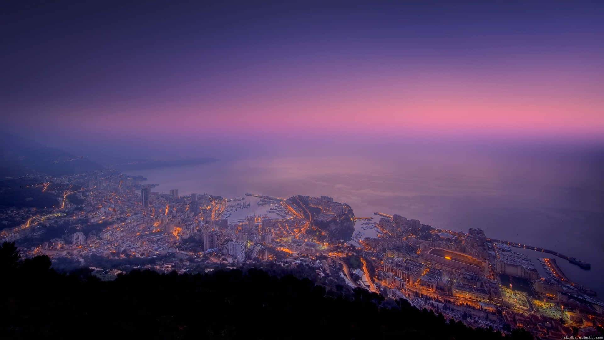 A View Of The City Of Monaco At Dusk