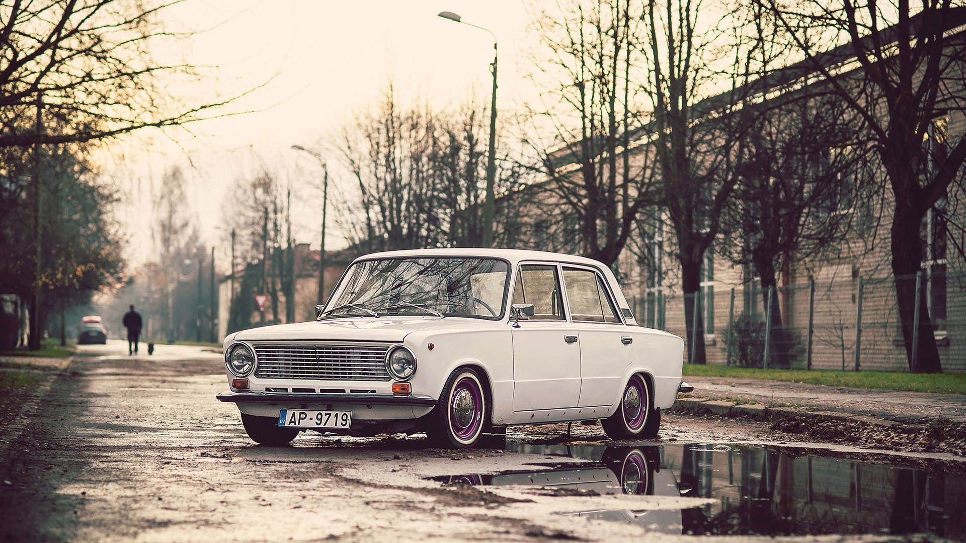 A Vintage Car In The Street Of Riga Background