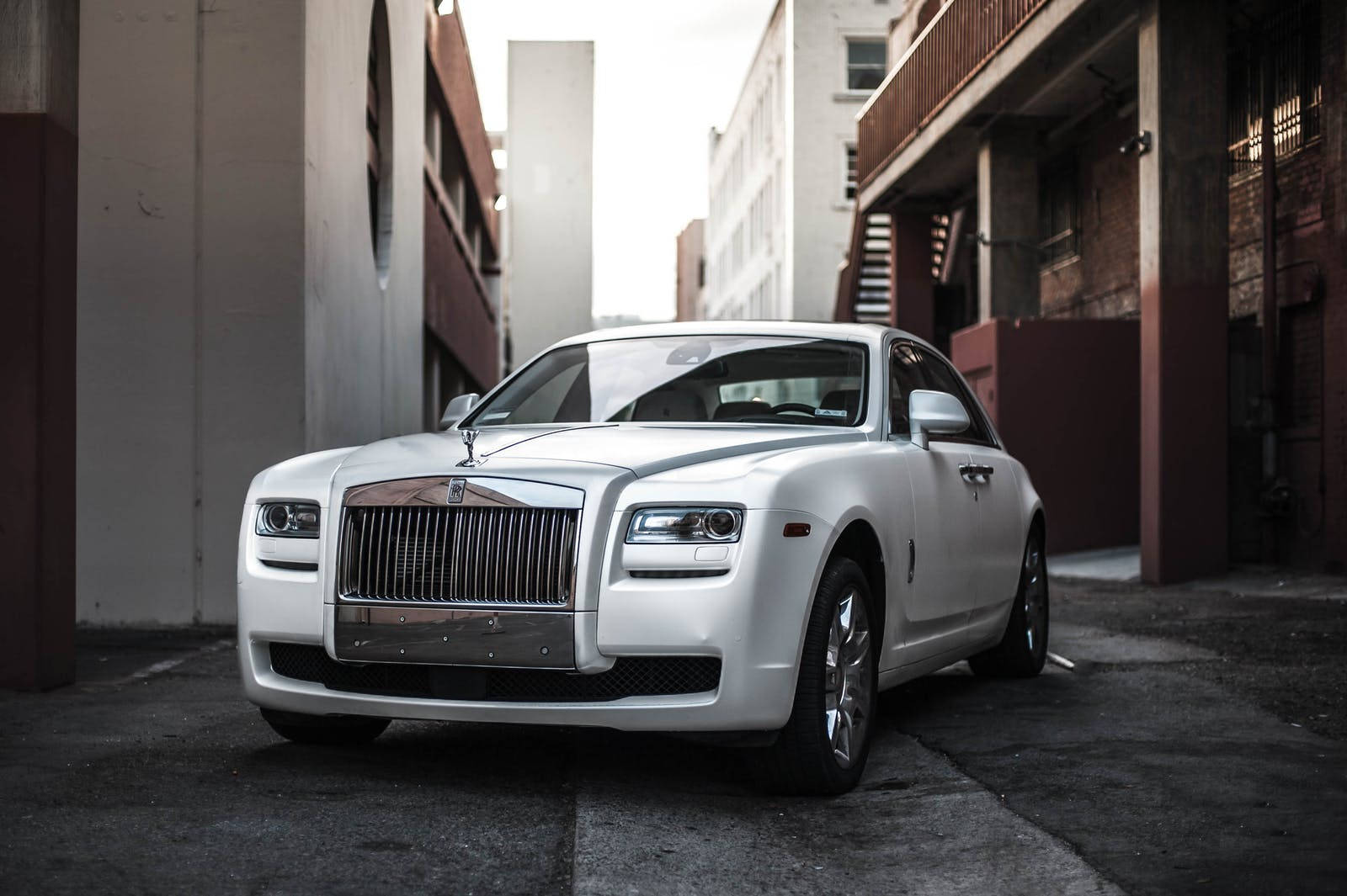 A Vision Of Prestige - White Ghost Luxury Car In An Alley Background