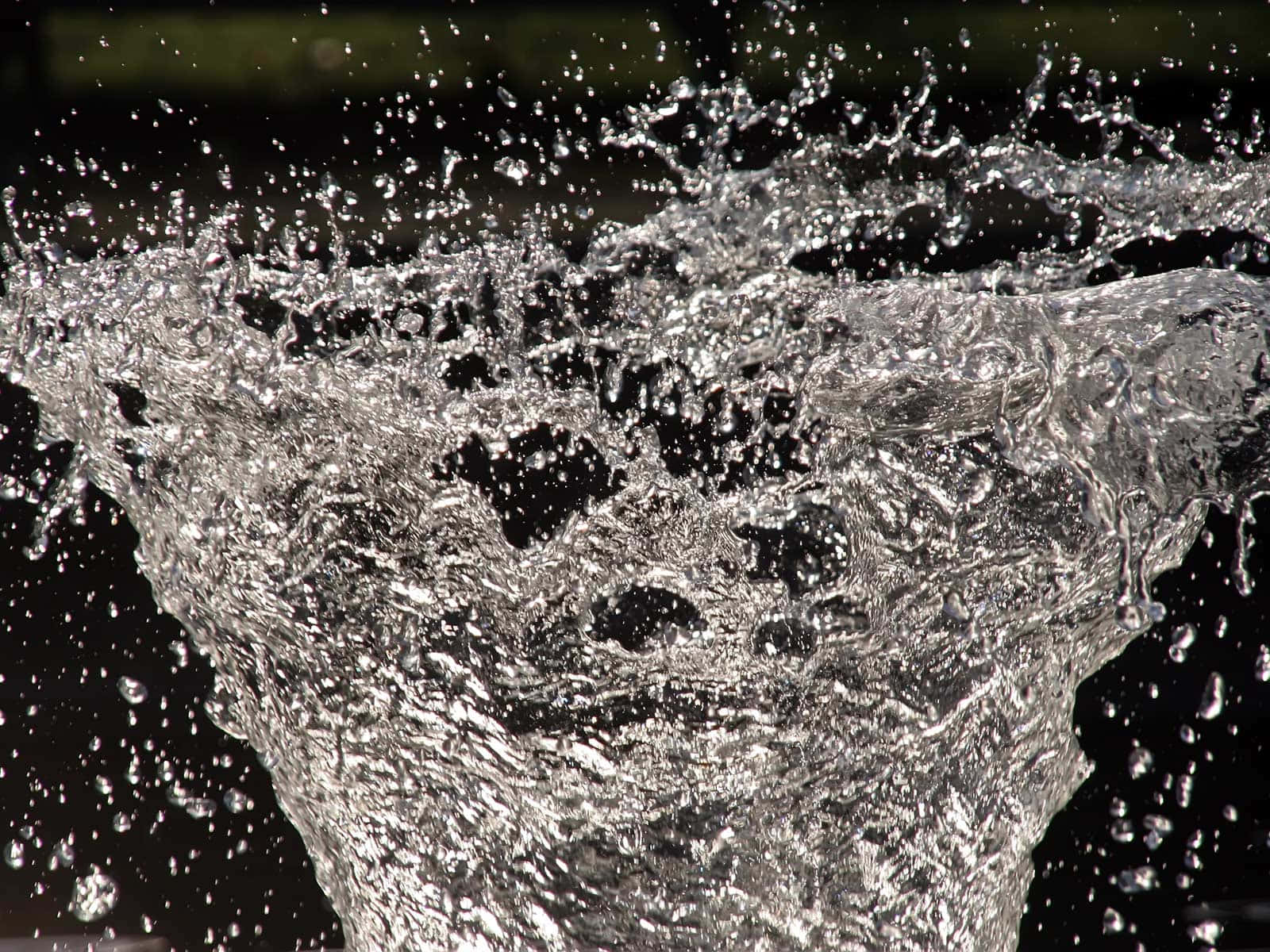 A Water Fountain With Water Splashing Out Of It Background