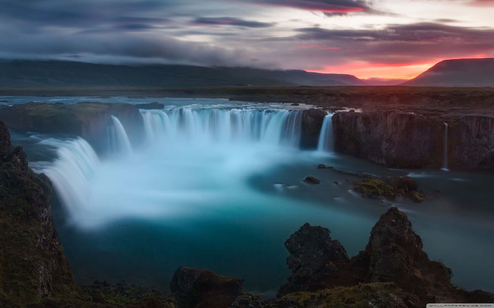 A Waterfall At Sunset In Iceland