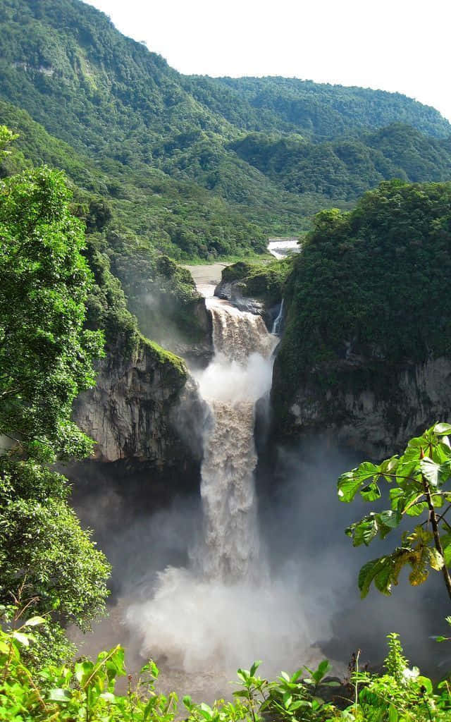 A Waterfall In The Middle Of A Lush Green Jungle Background