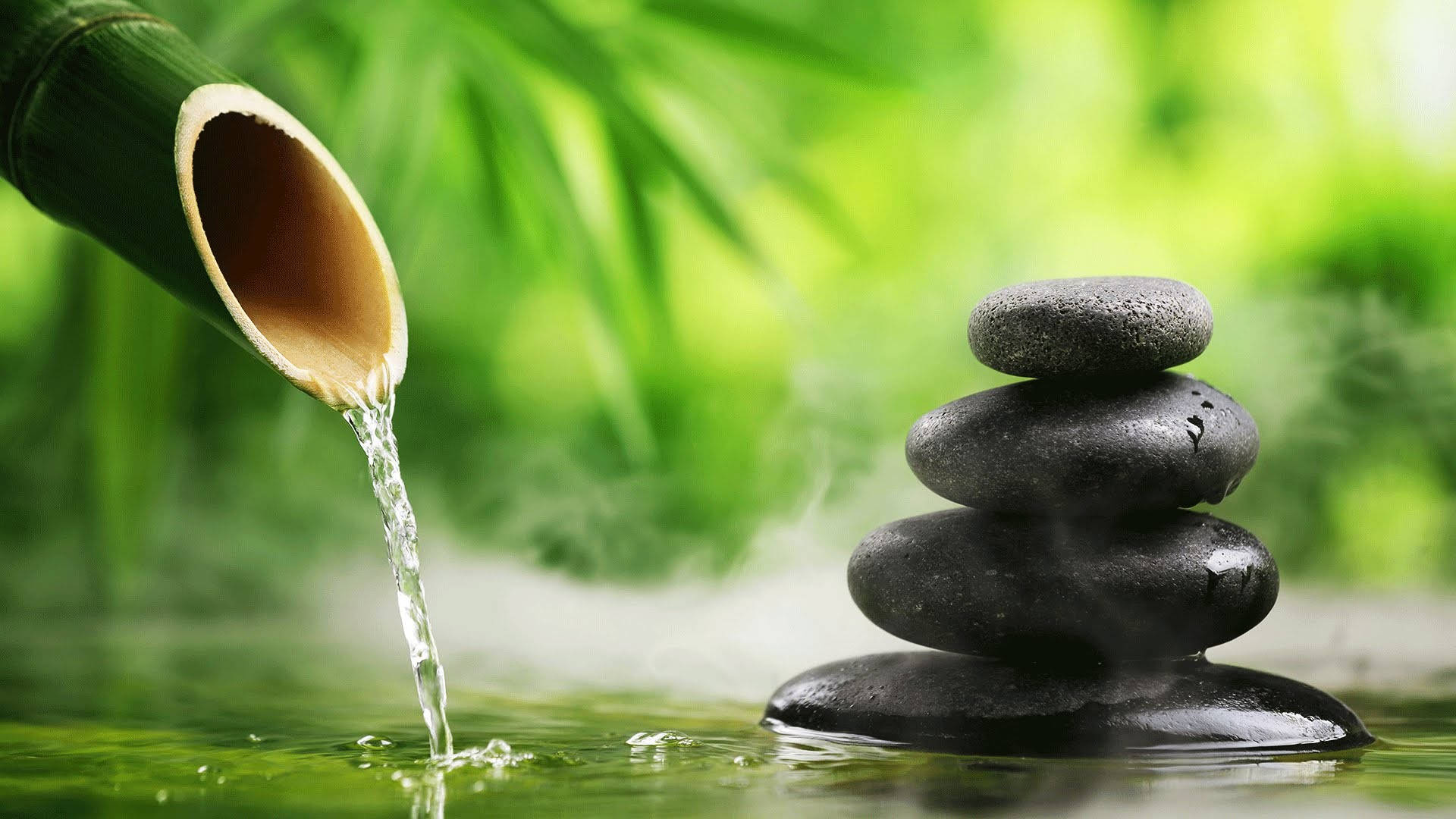 A Waterfall Is Pouring Water Over A Bamboo And Stone Background