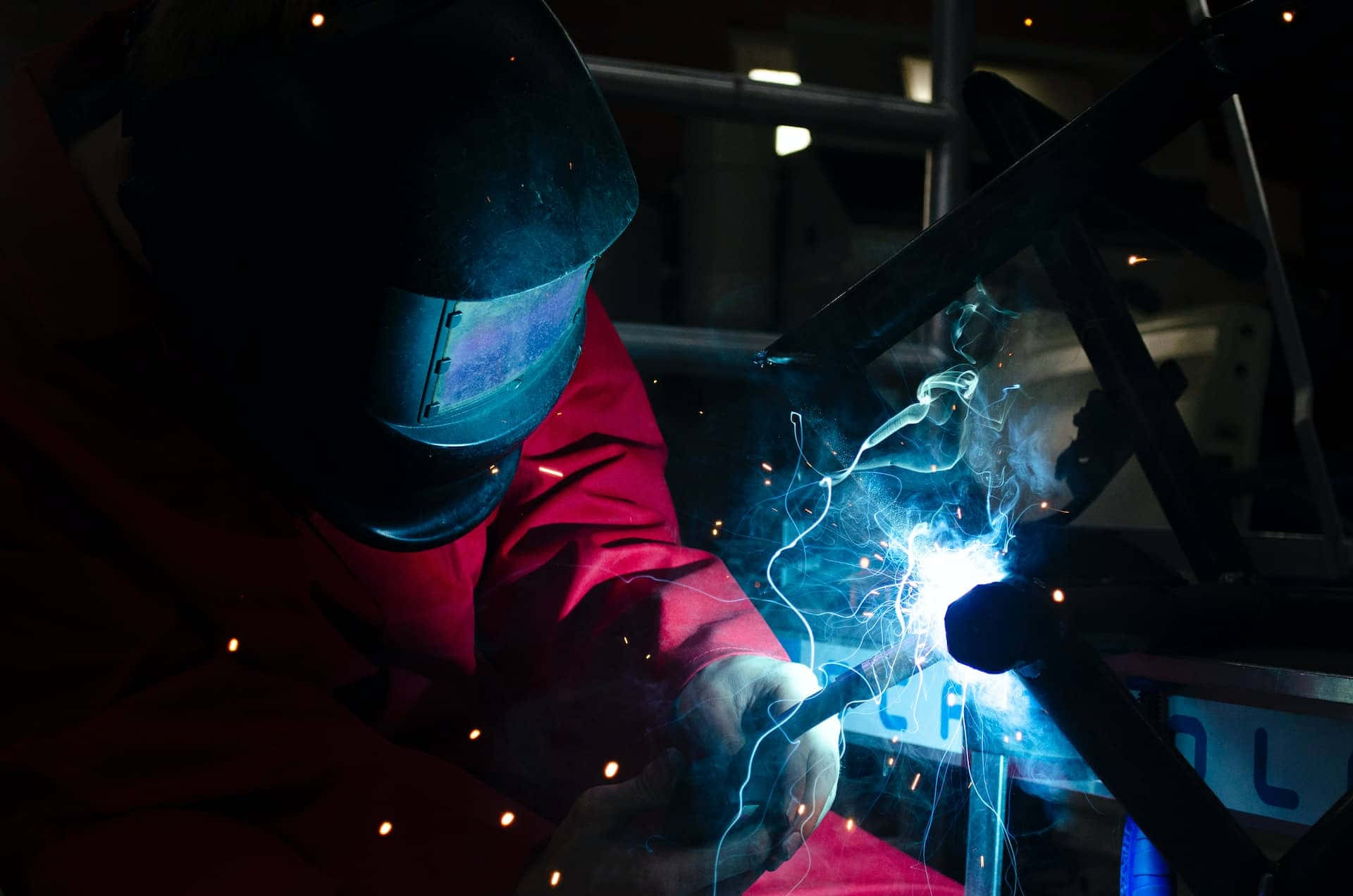 A Welder Is Welding Metal In A Dark Room