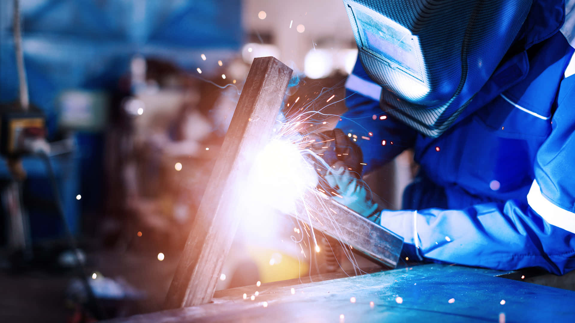 A Welder Is Welding Metal In A Factory Background