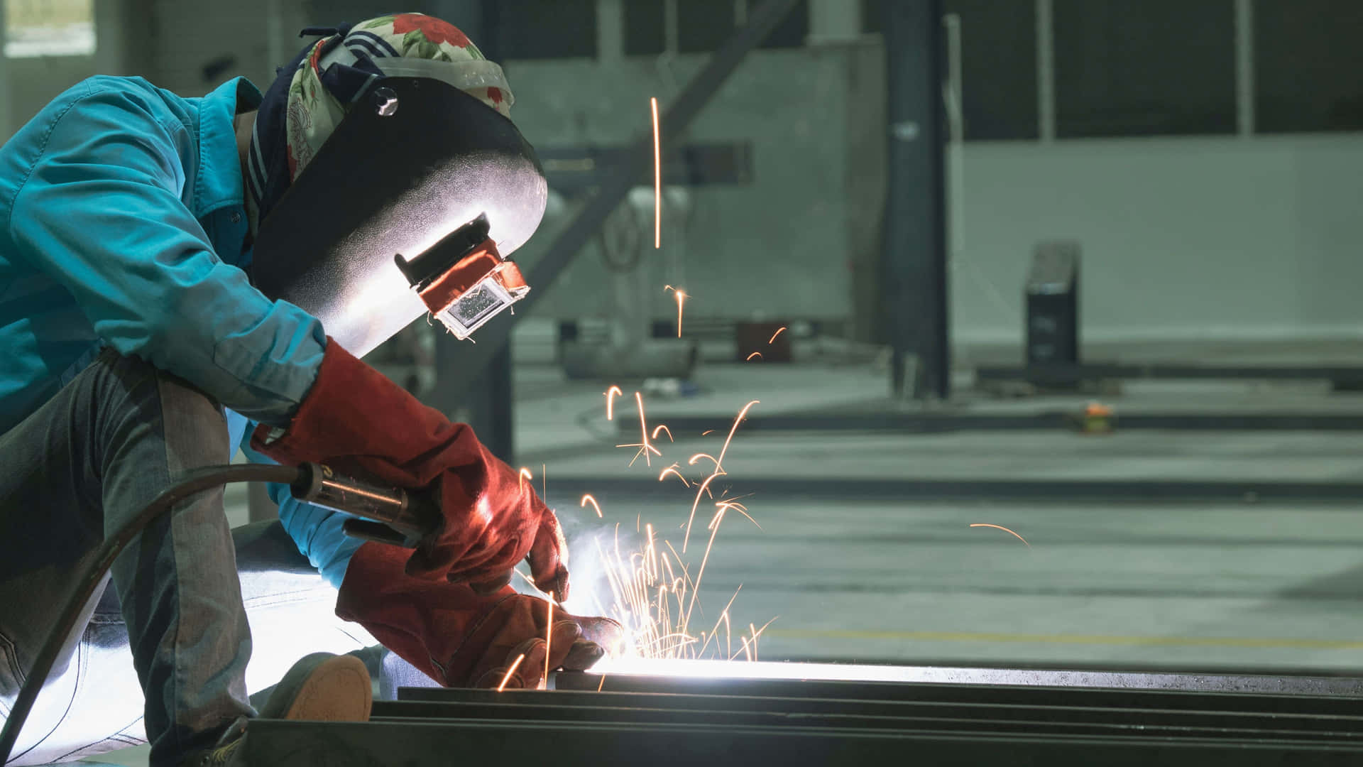 A Welder Is Welding Metal In A Factory Background