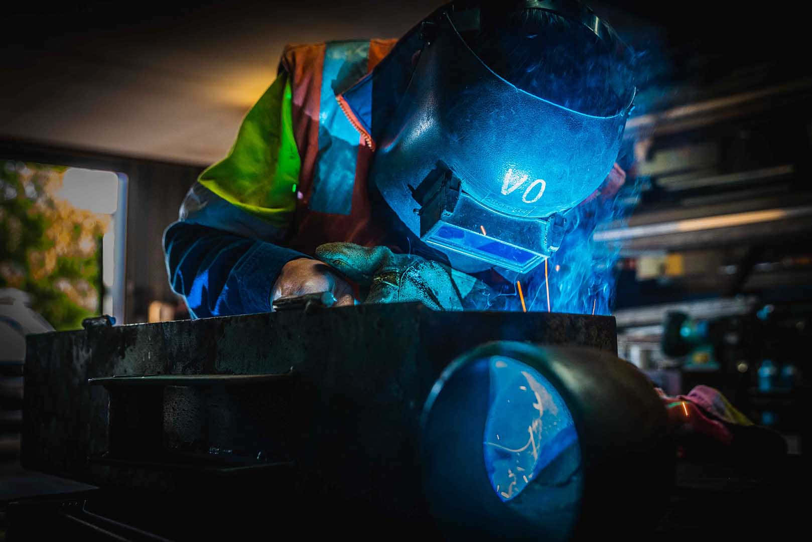 A Welder Working On A Metal Object Background