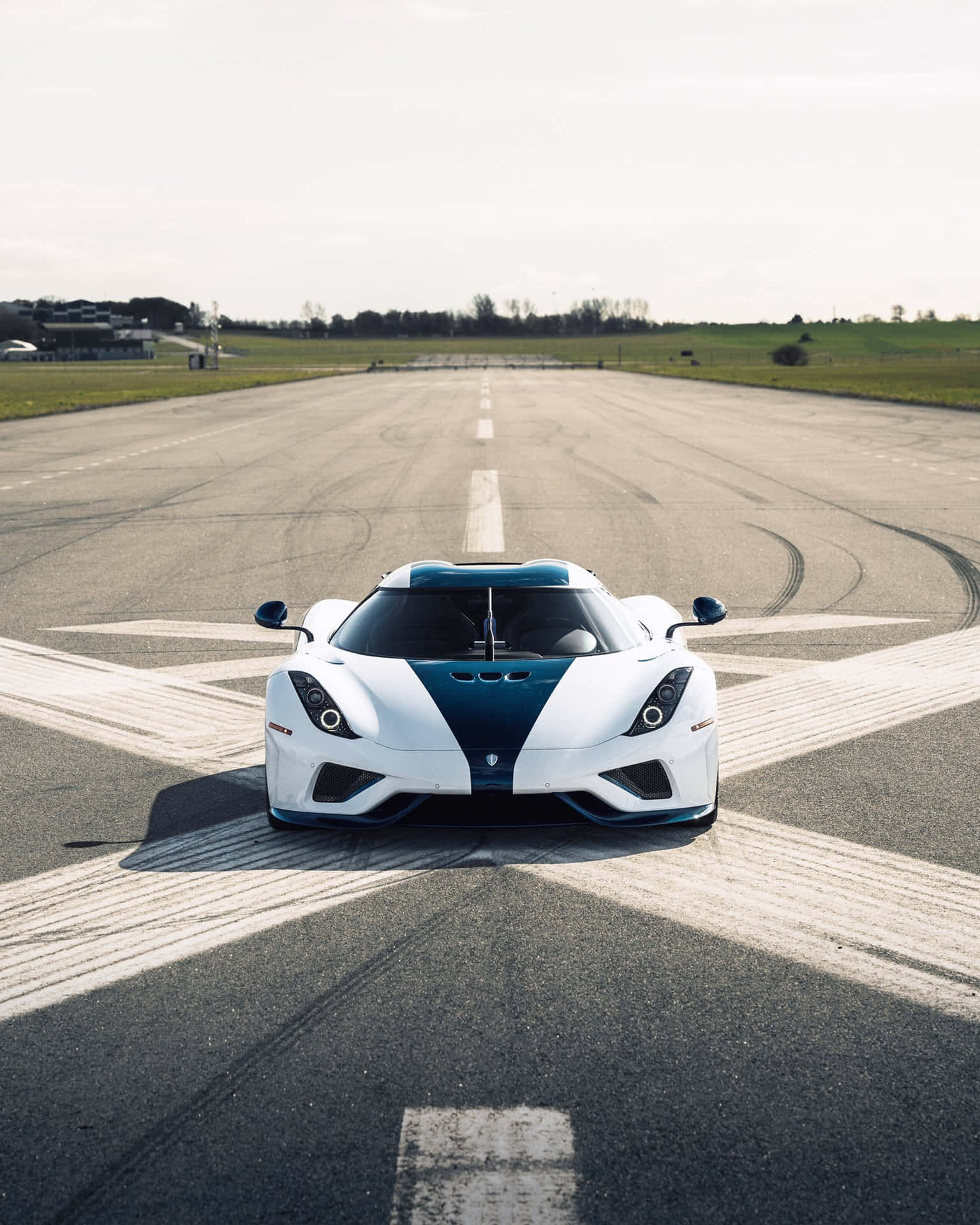 A White And Blue Sports Car On A Runway Background