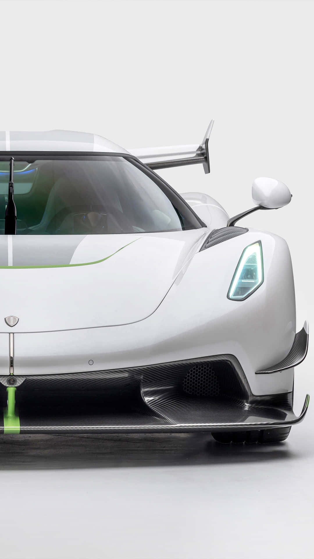 A White And Green Supercar Is Shown In A Studio Background