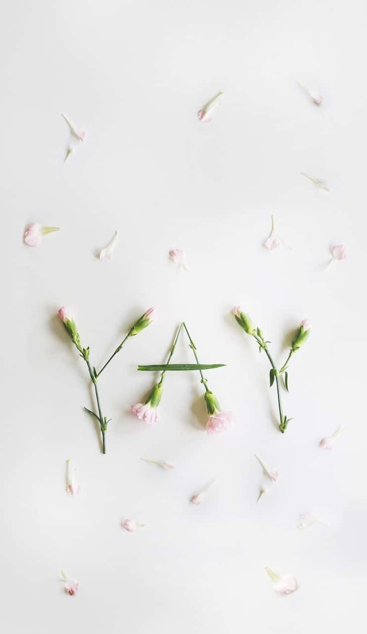 A White Background With Pink Flowers Arranged In The Shape Of The Word Yay Background