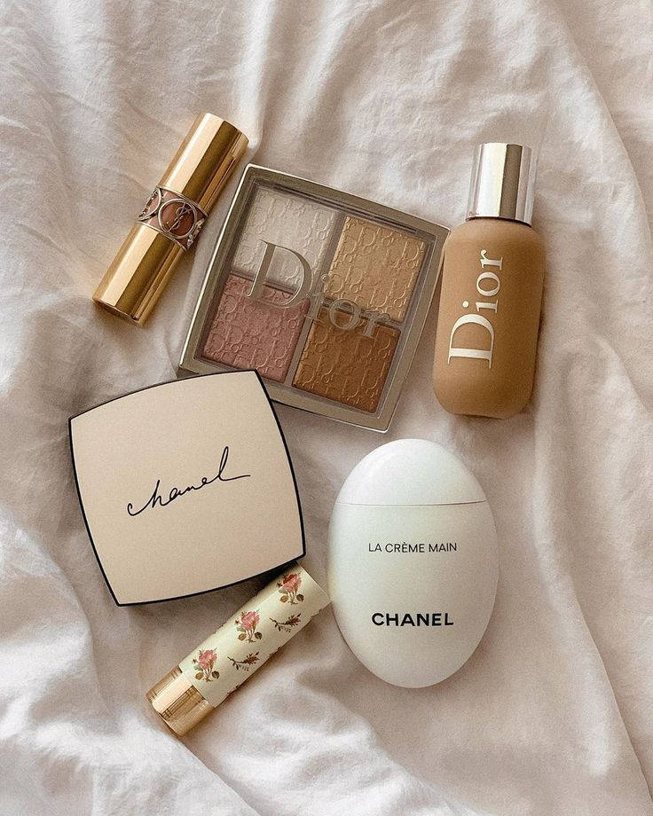 A White Bed With Cosmetics And A Chanel Bag Background