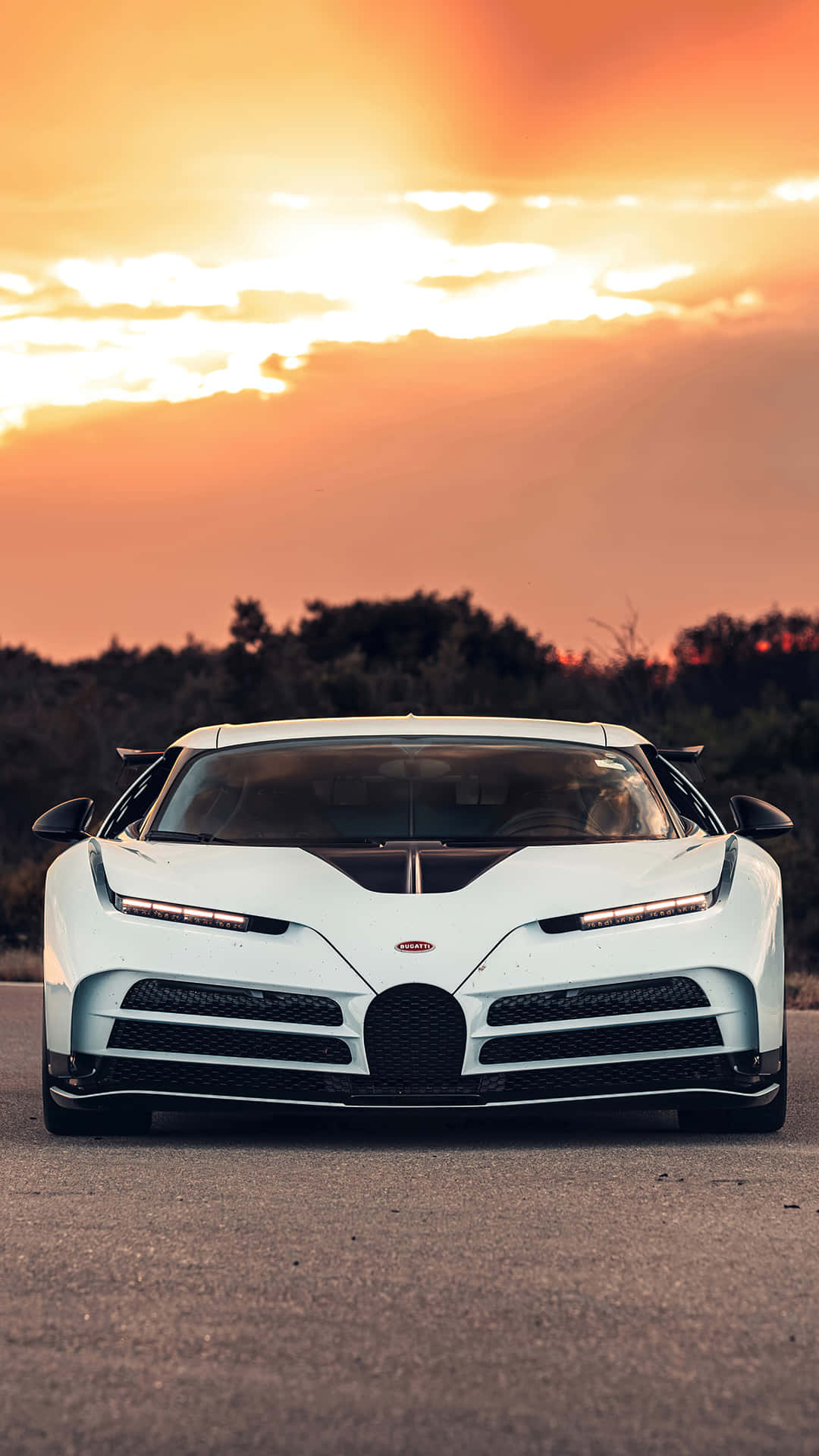 A White Bugatti Chiron Sitting On The Road At Sunset Background