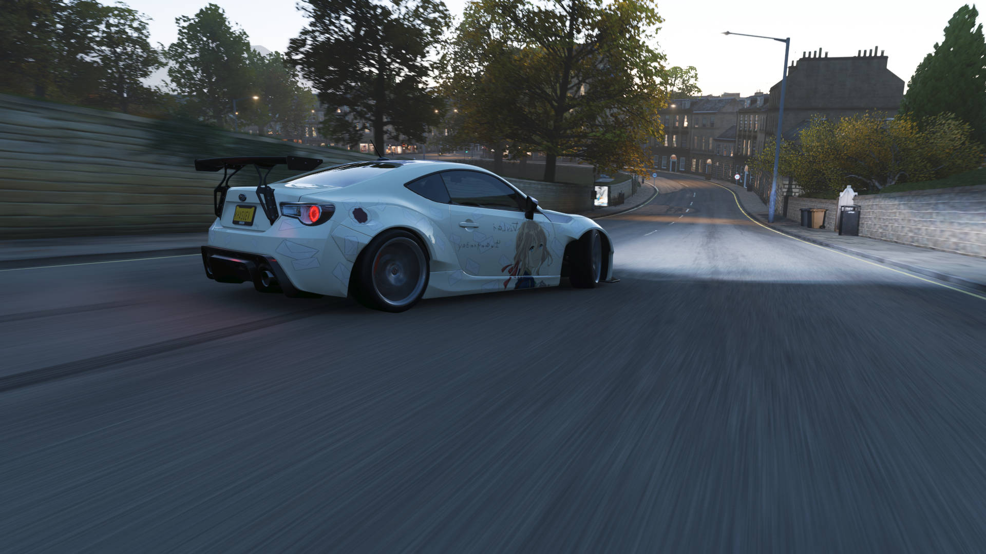 A White Car Driving Down A Street Background