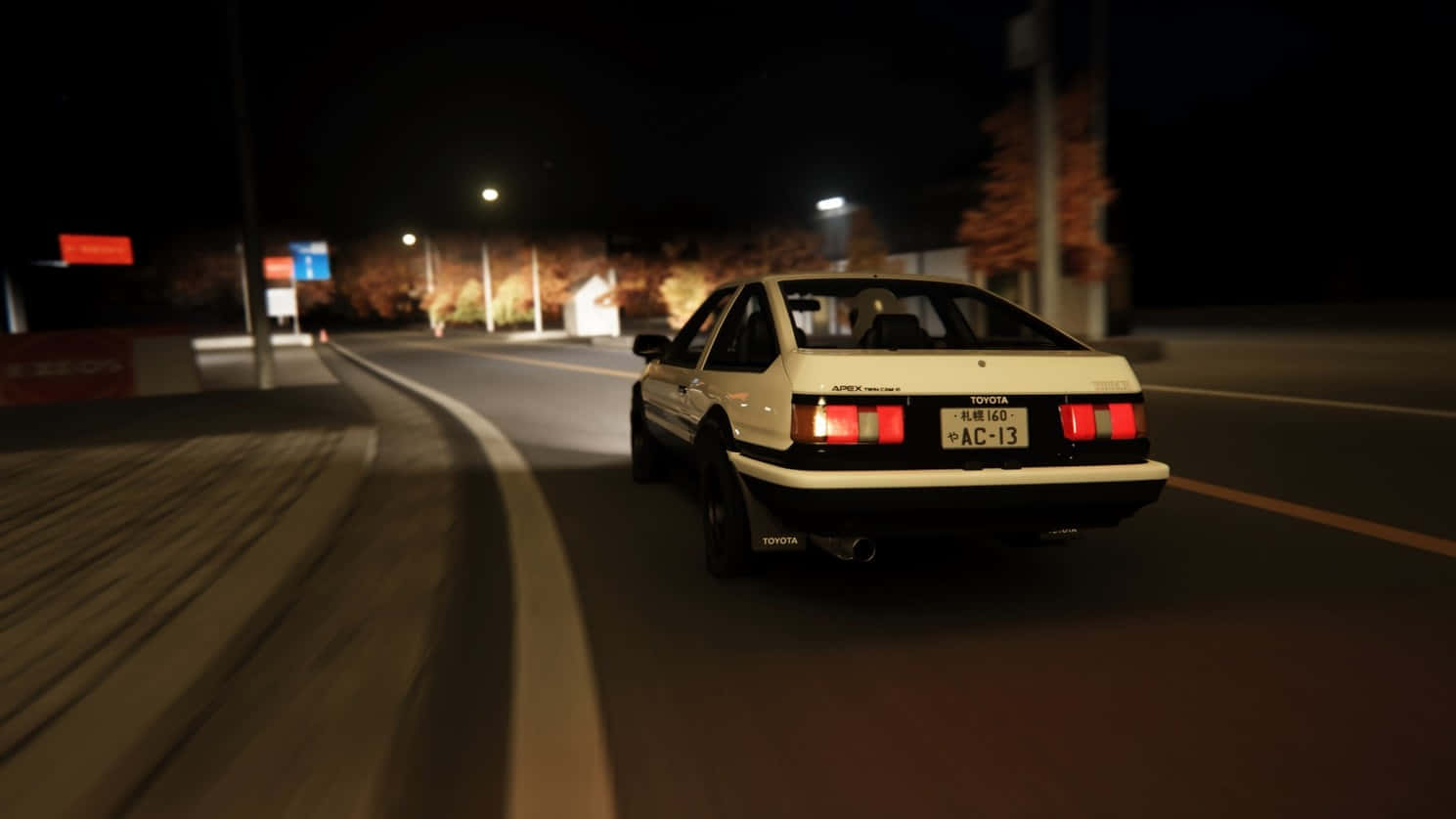 A White Car Driving Down The Street At Night