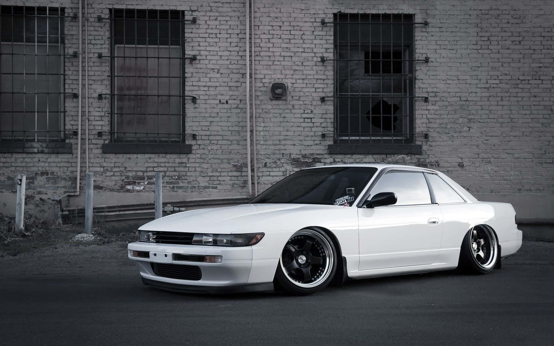 A White Car Parked In Front Of A Building Background