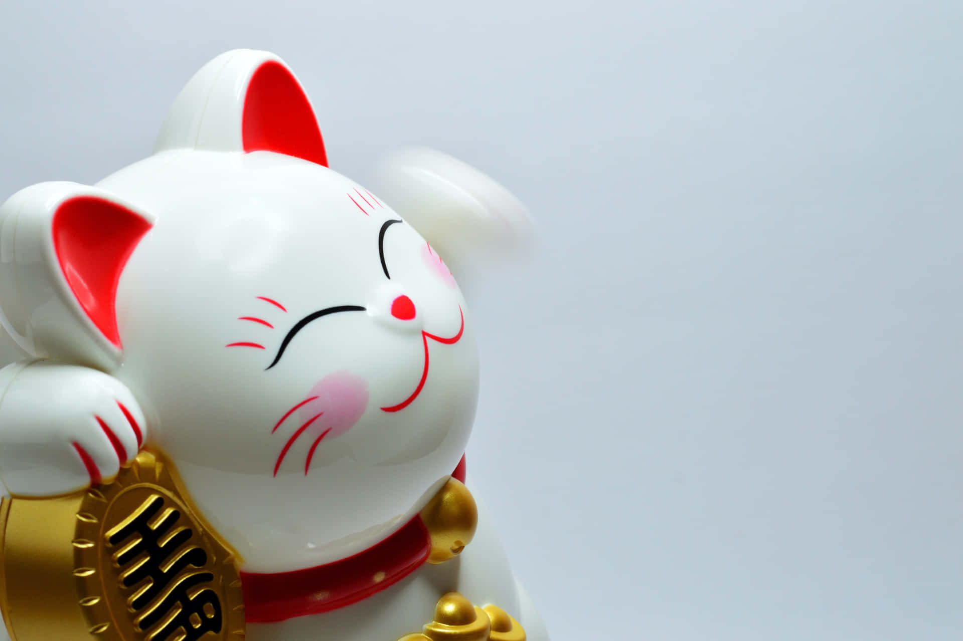 A White Cat Statue With A Gold Ring Background