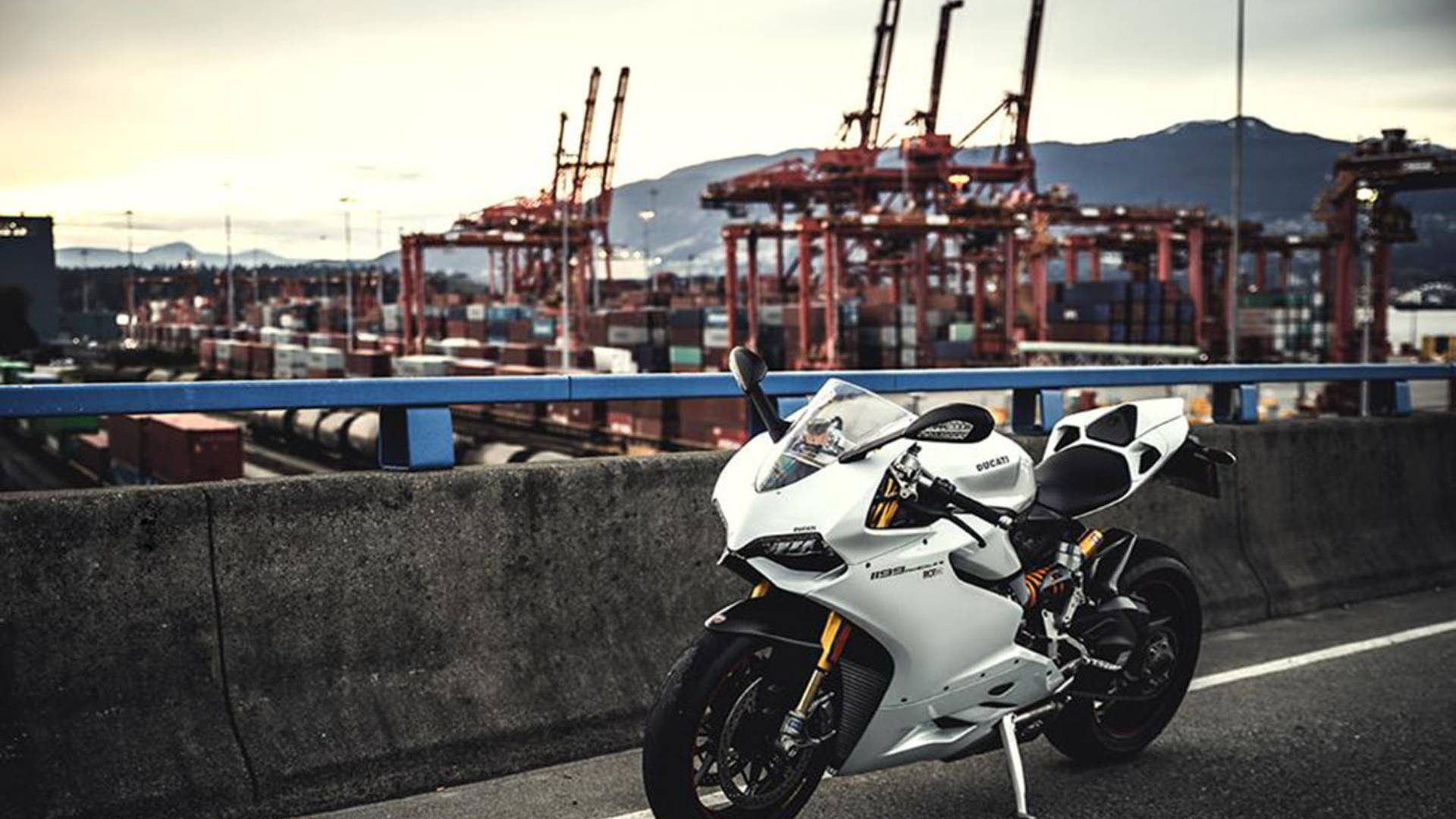A White Ducati Motorcycle In A Container Port Background