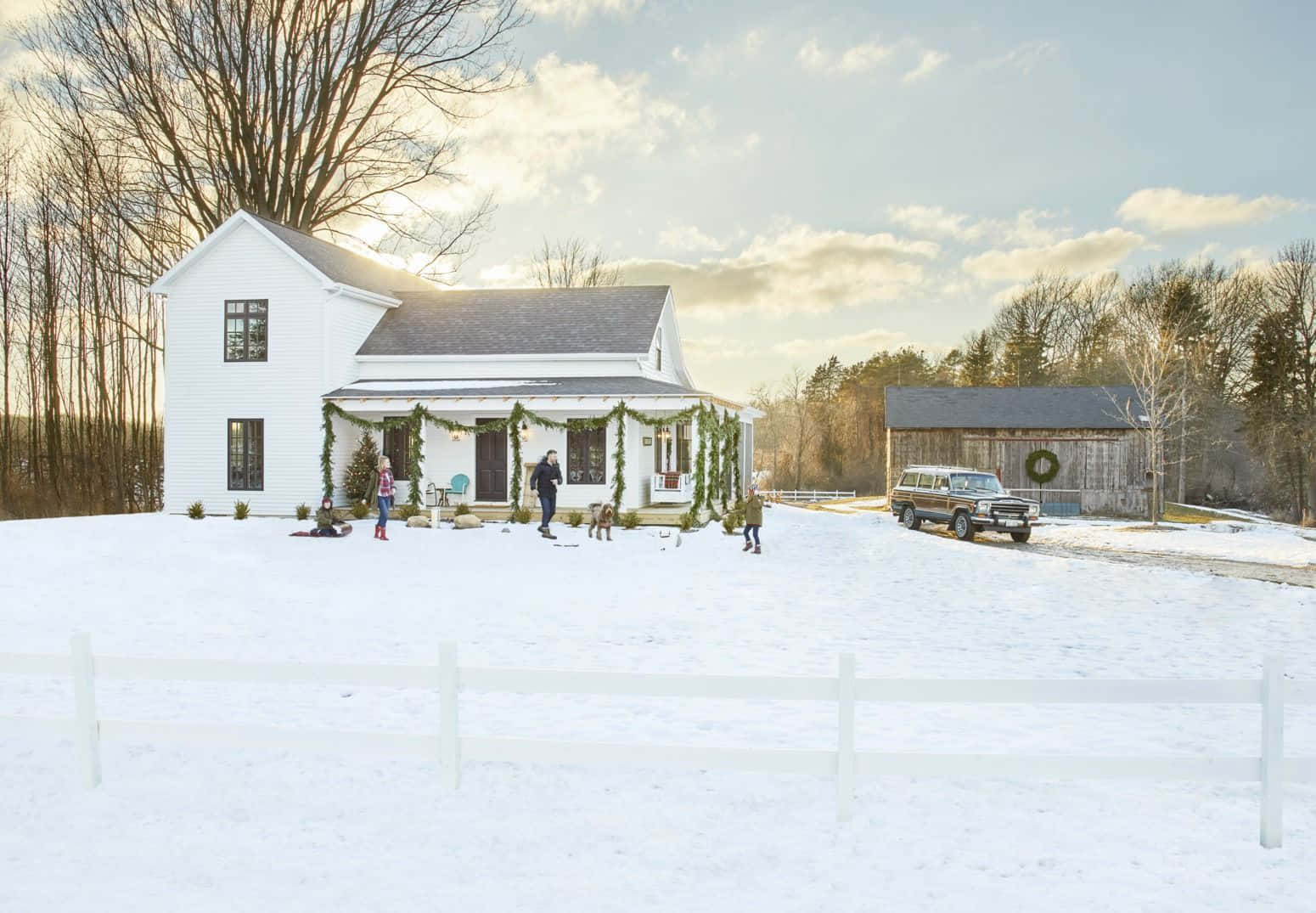 A White Farmhouse With A Snow Covered Yard