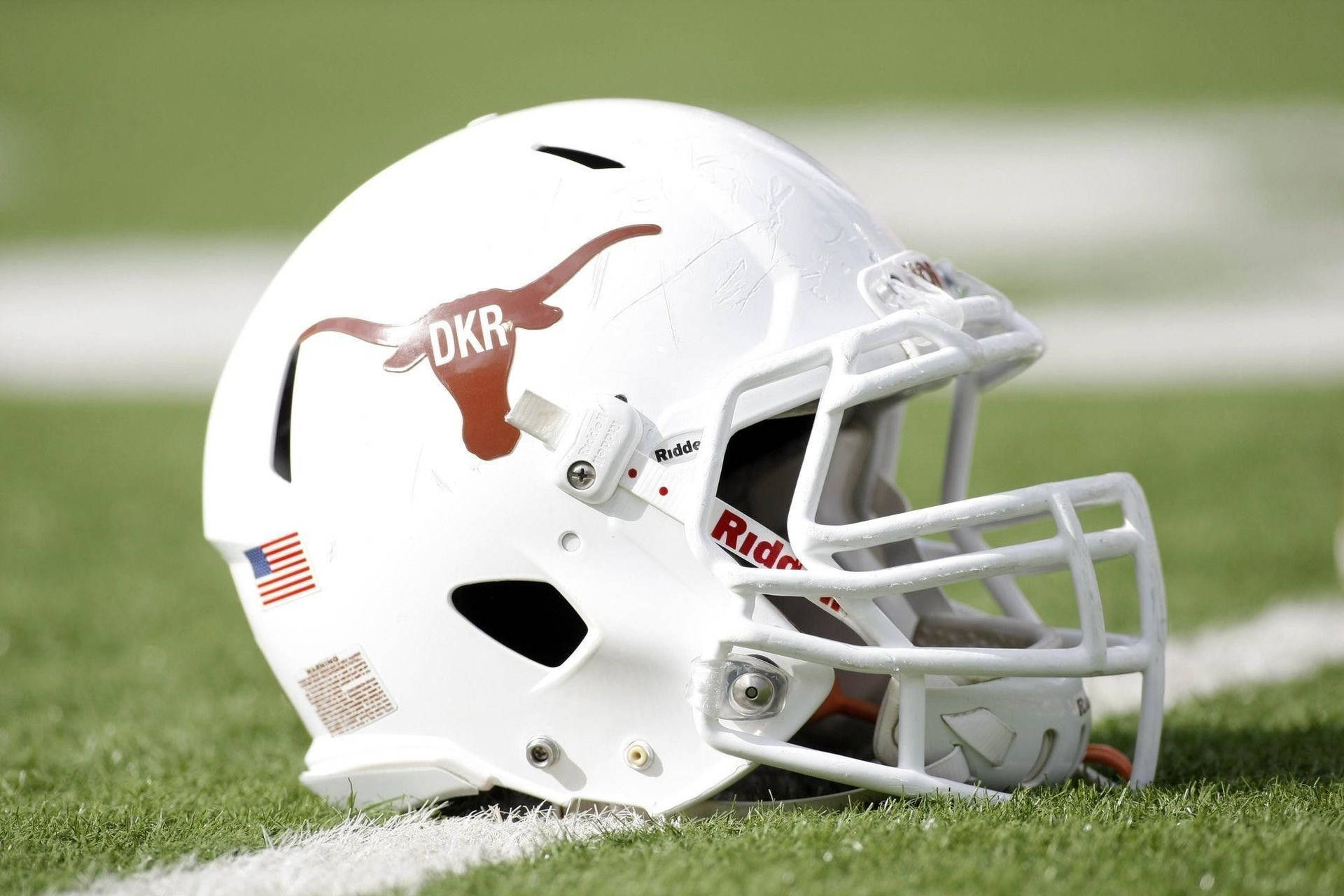 A White Football Helmet Sits On The Field