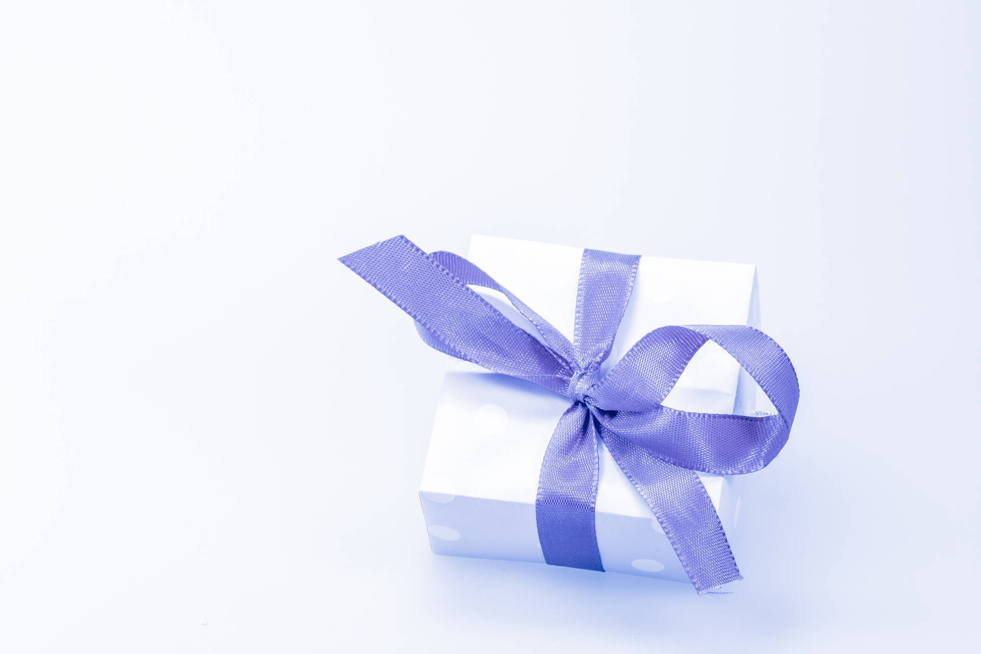 A White Gift Box With A Purple Ribbon On A White Background Background