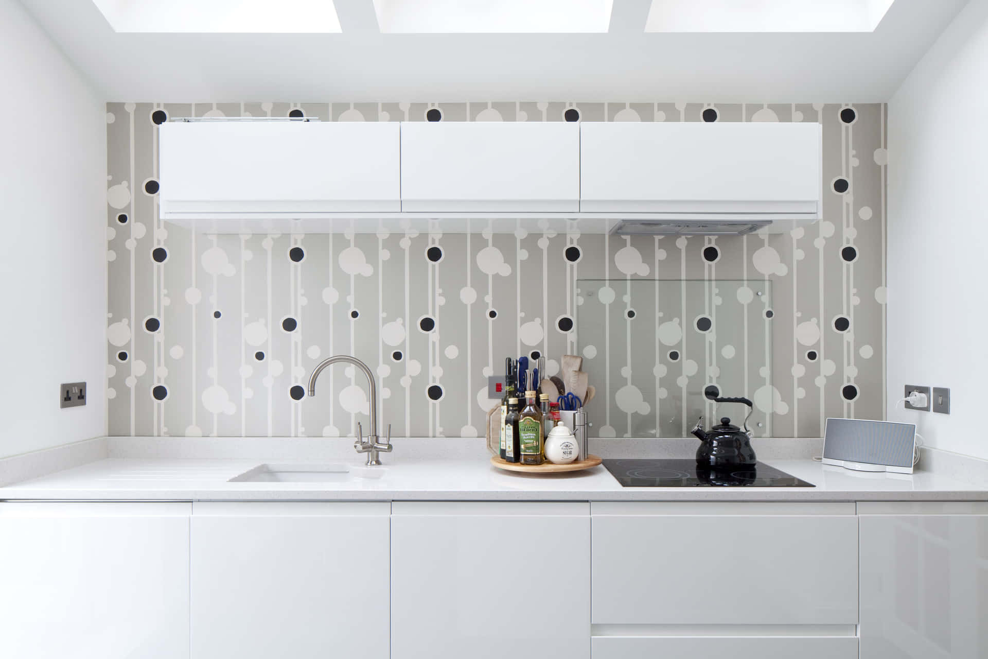 A White Kitchen With A Black And White Polka Dot Wallpaper Background