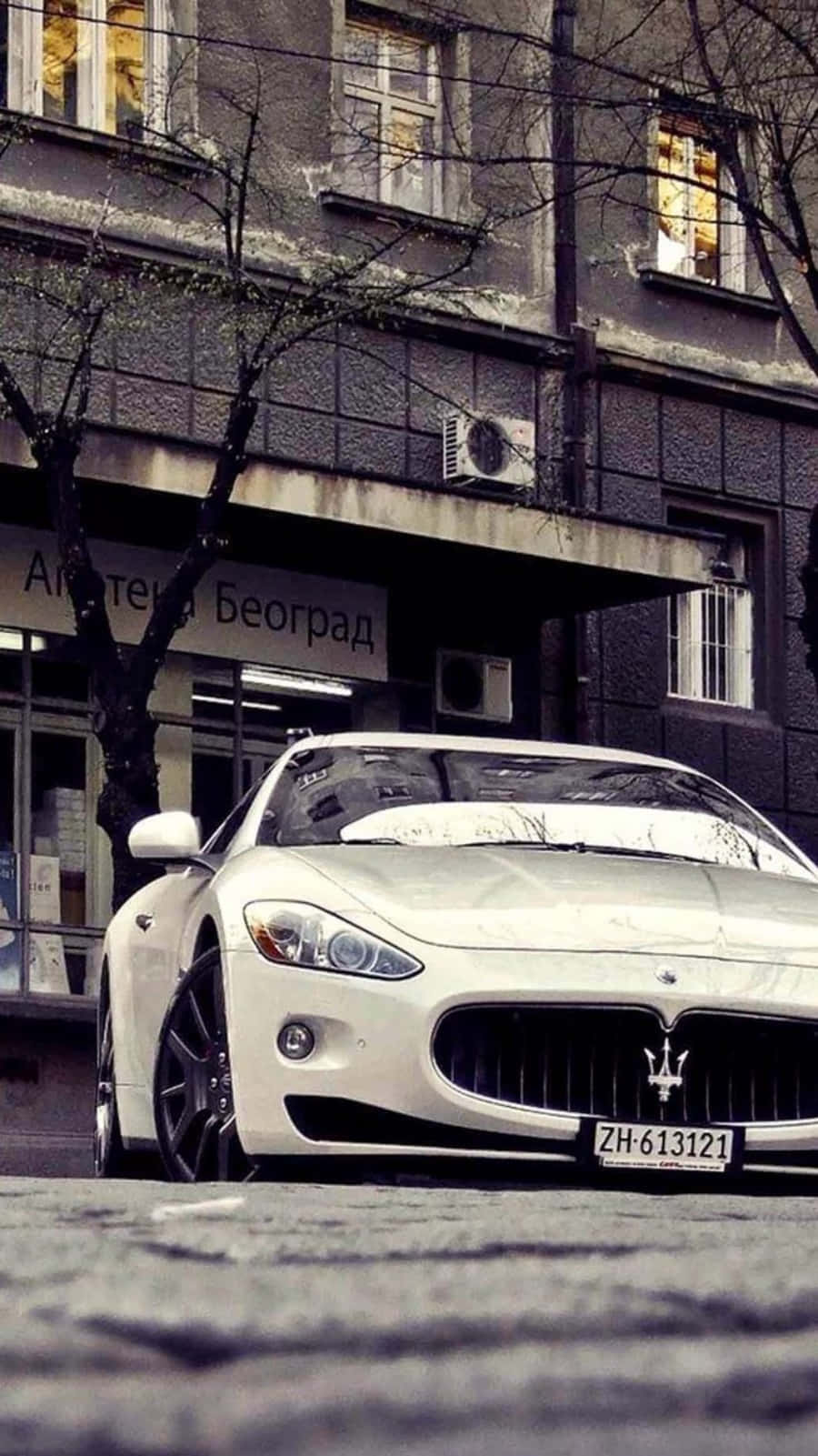 A White Maserati Parked On The Street Background