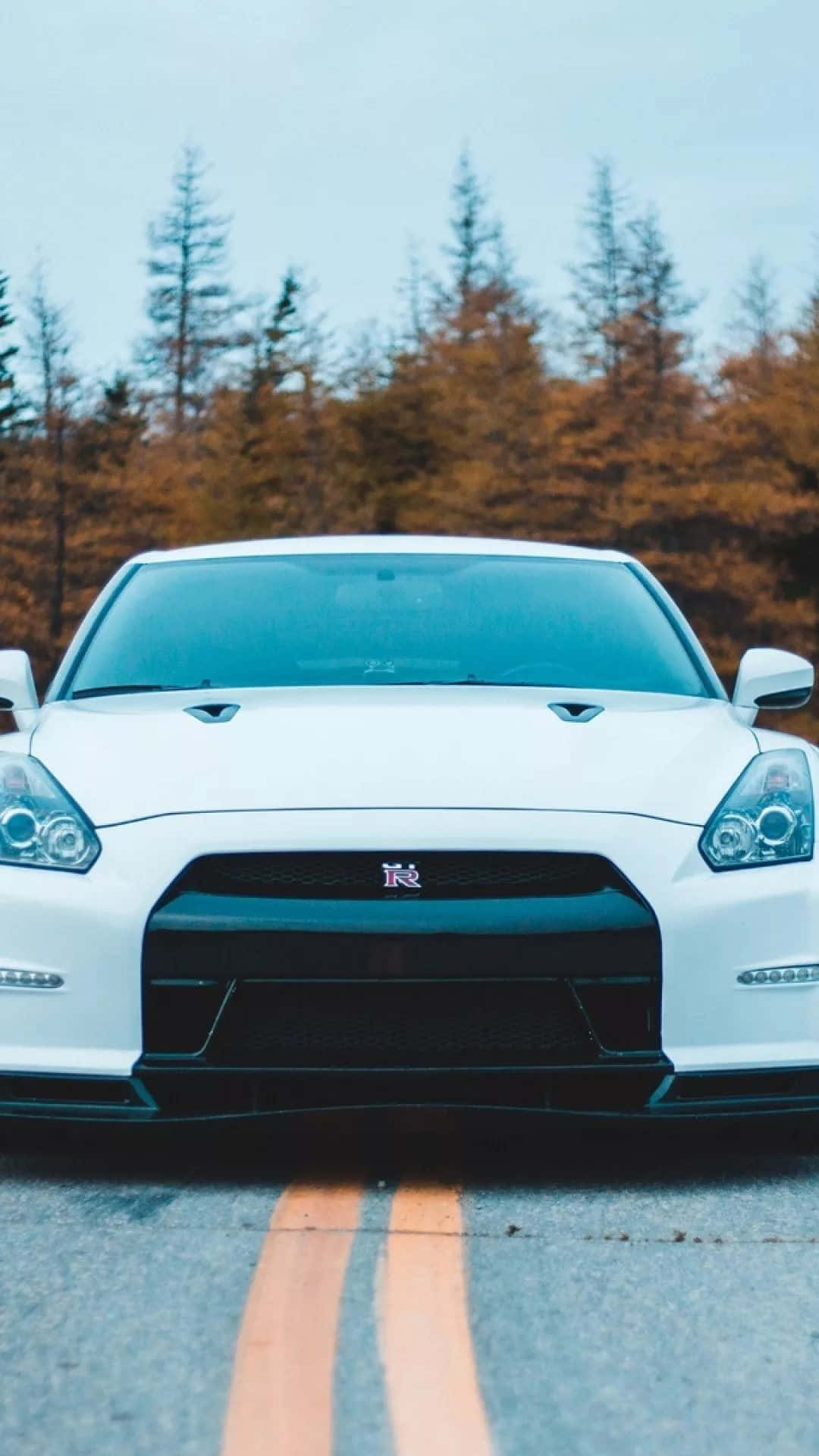 A White Nissan Gtr Parked On The Road Background