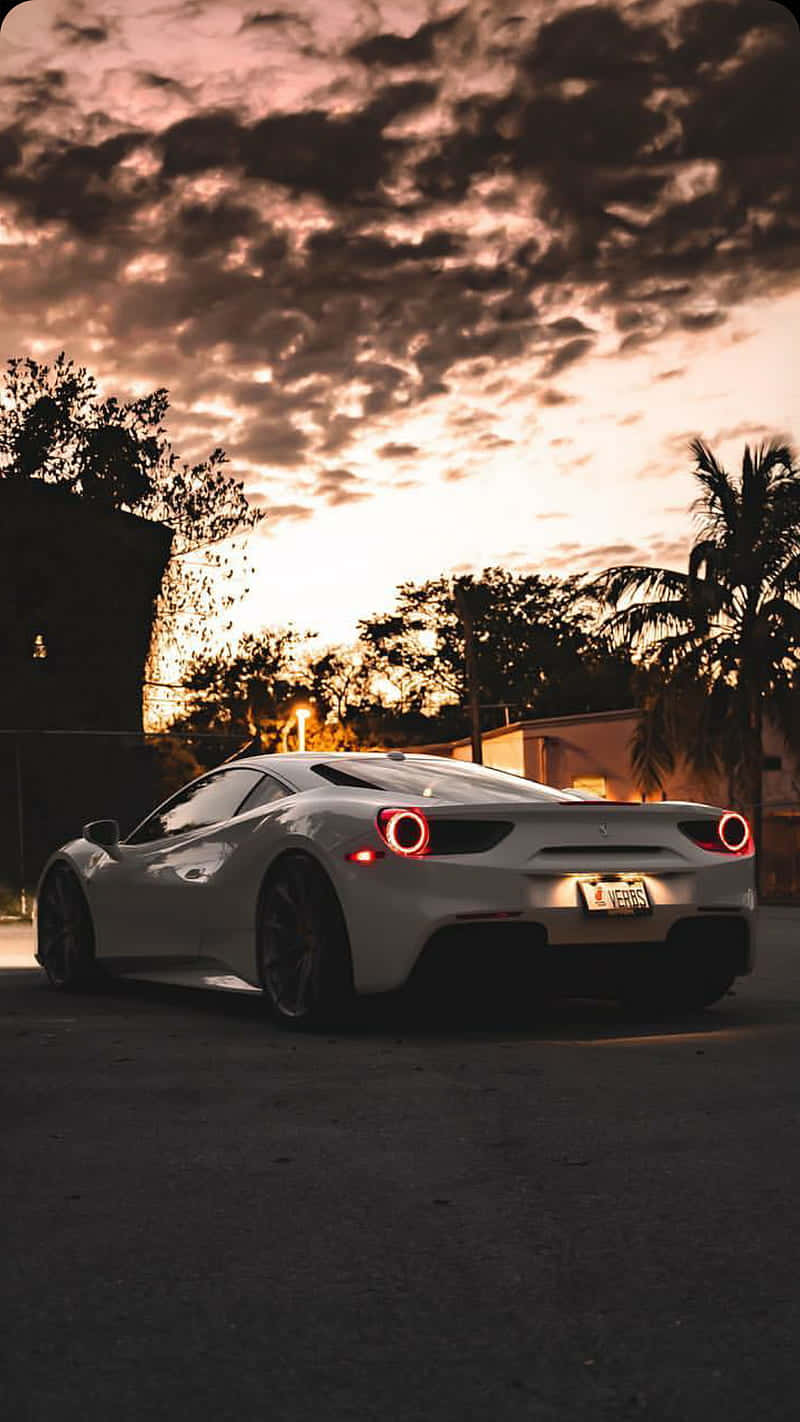 A White Sports Car Parked In The Street At Sunset