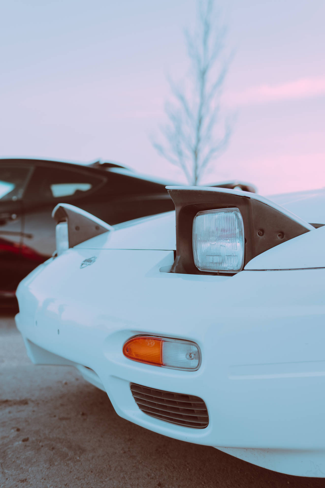 A White Sports Car Parked Next To A Black Car Background