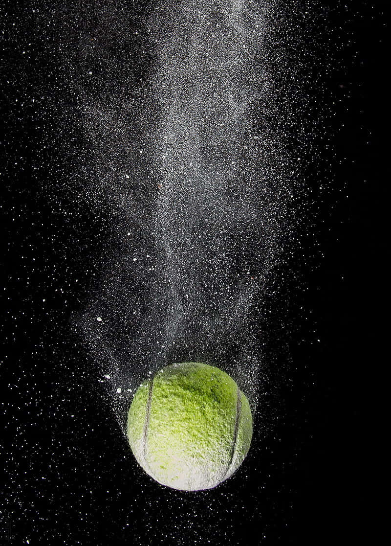 A White Tennis Ball Resting Against An Off-white Grass Surface Background
