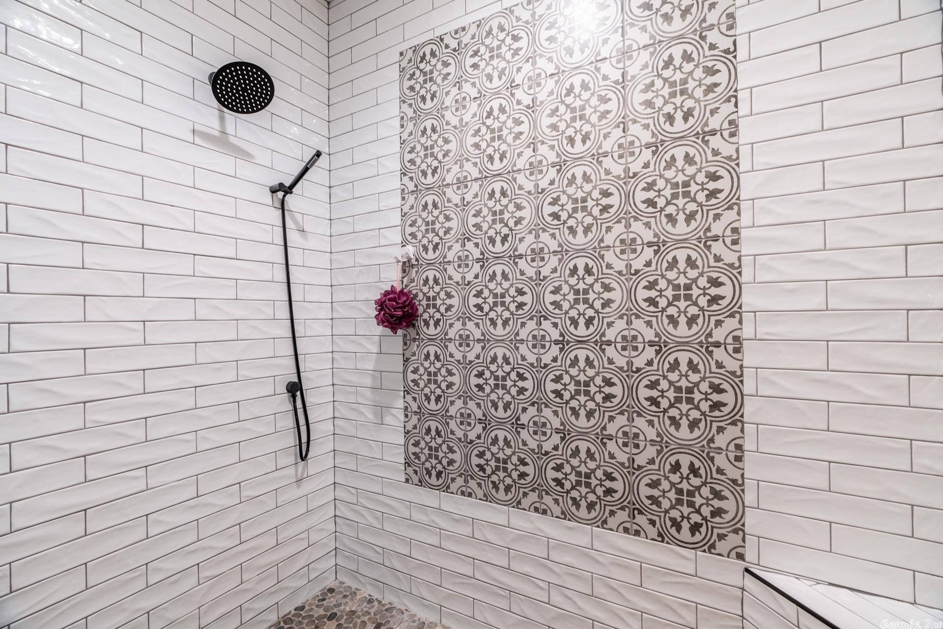 A White Tiled Shower With A Black And White Tiled Wall Background