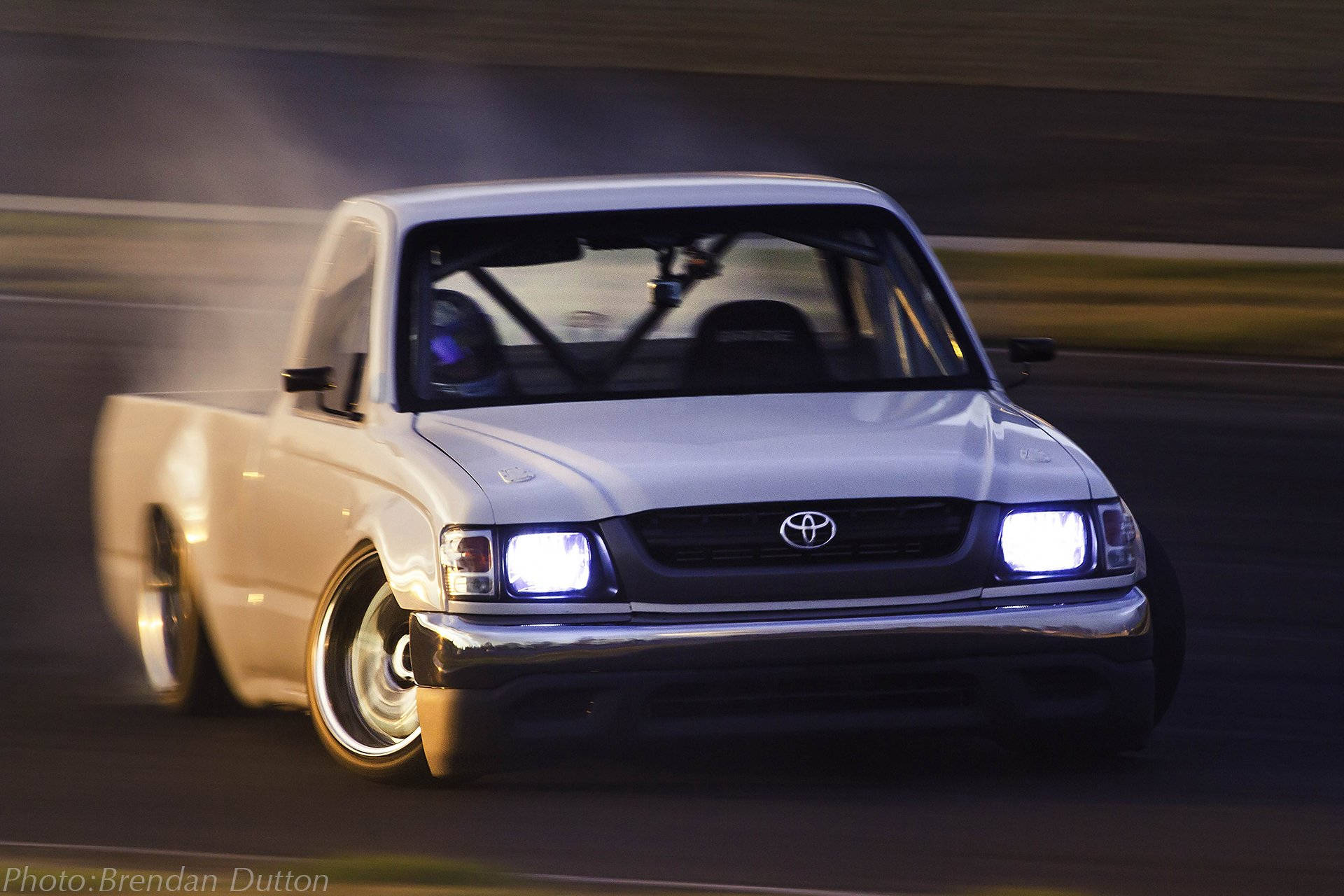 A White Truck Driving On A Track Background