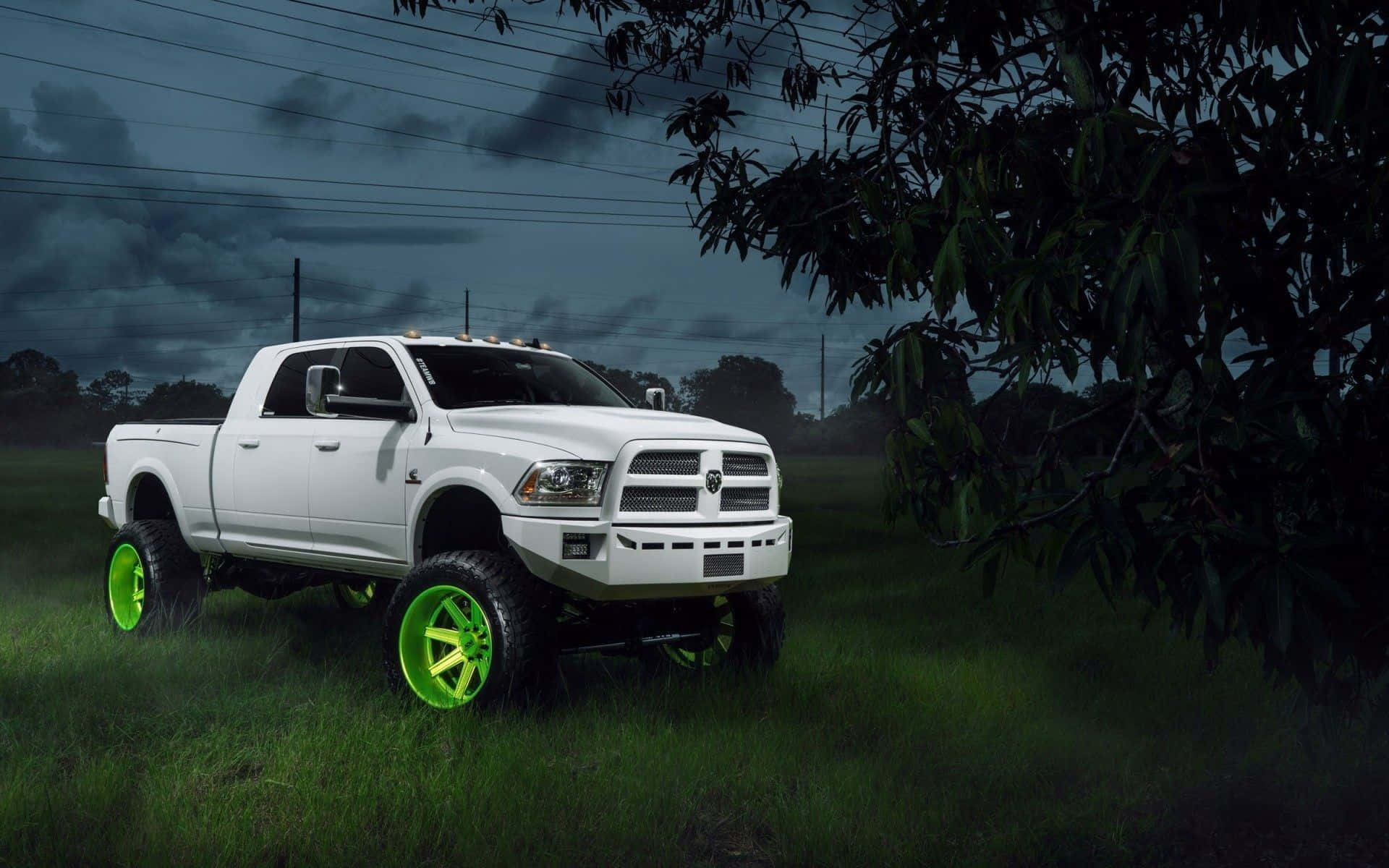 A White Truck With Green Wheels In The Grass Background