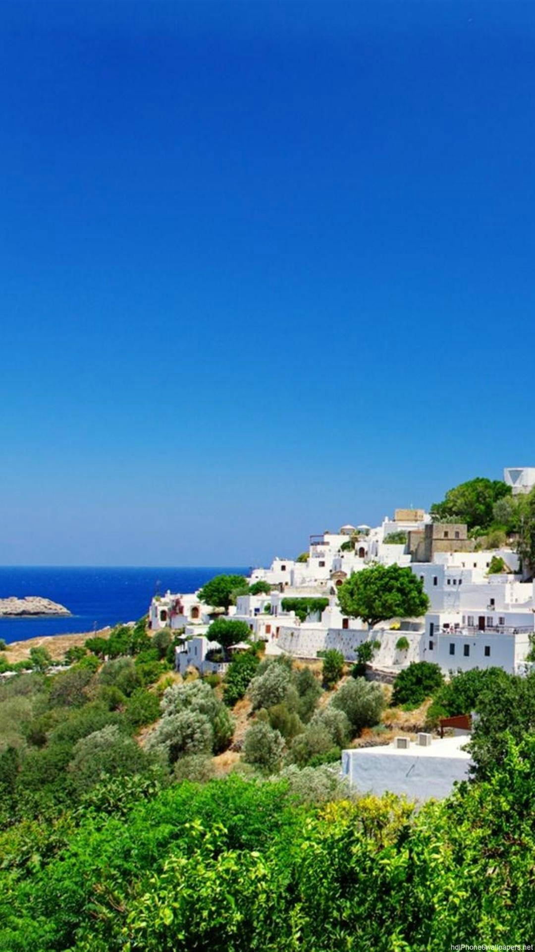 A White Village With Trees And A Blue Sky