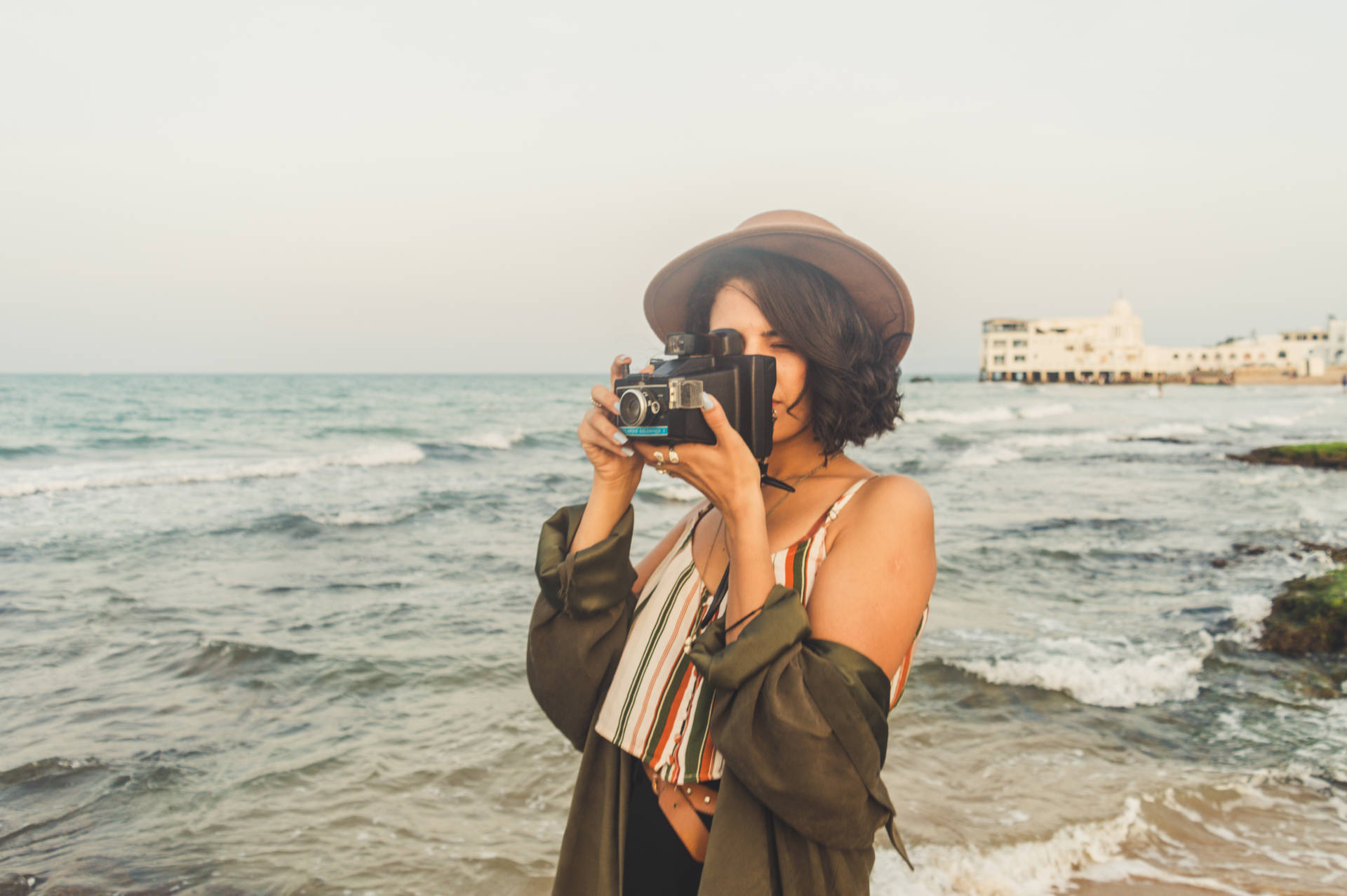 A Woman Capturing Her Special Moment On A Beach Background