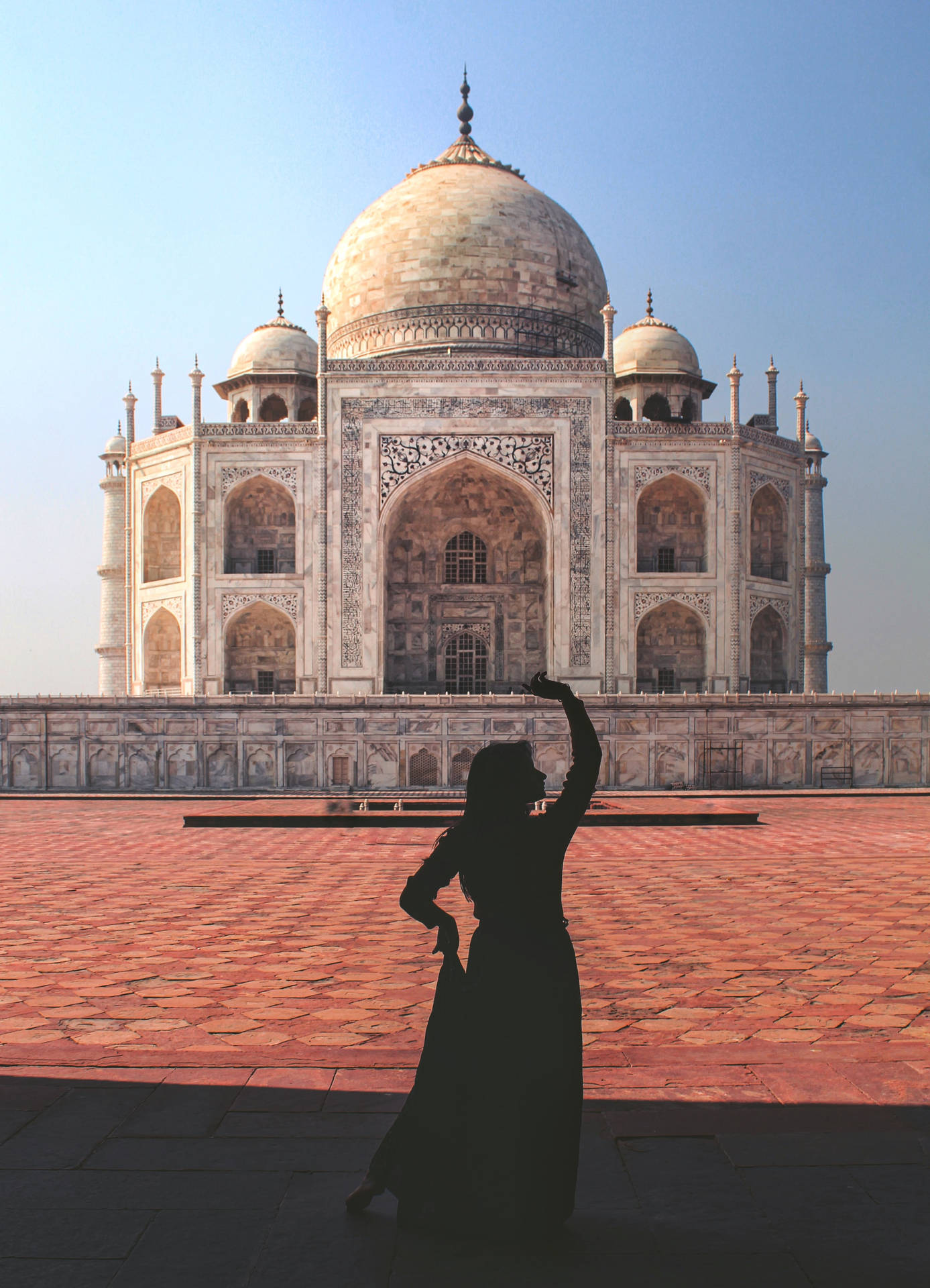 A Woman Dancing In Front Of The Taj Mahal Background