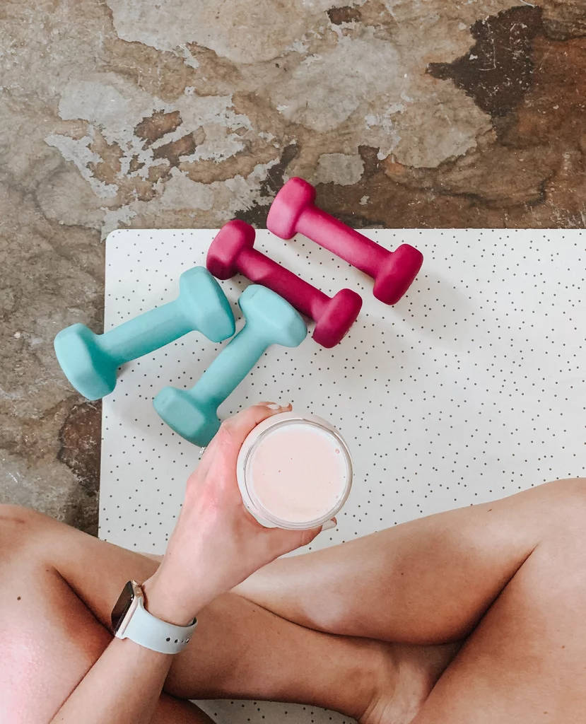 A Woman Holding A Cup Of Coffee And Dumbbells Background