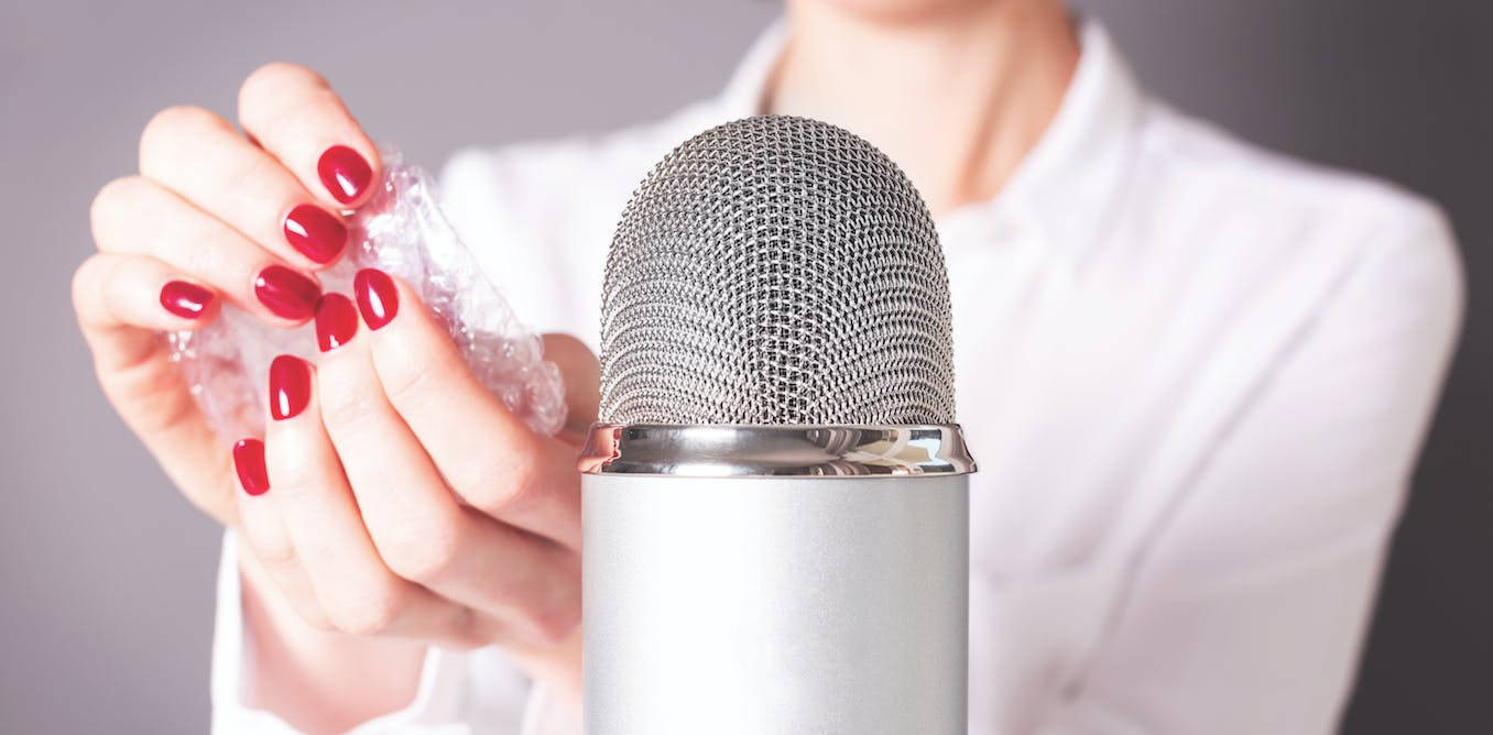 A Woman Holding A Microphone With Her Nails On It