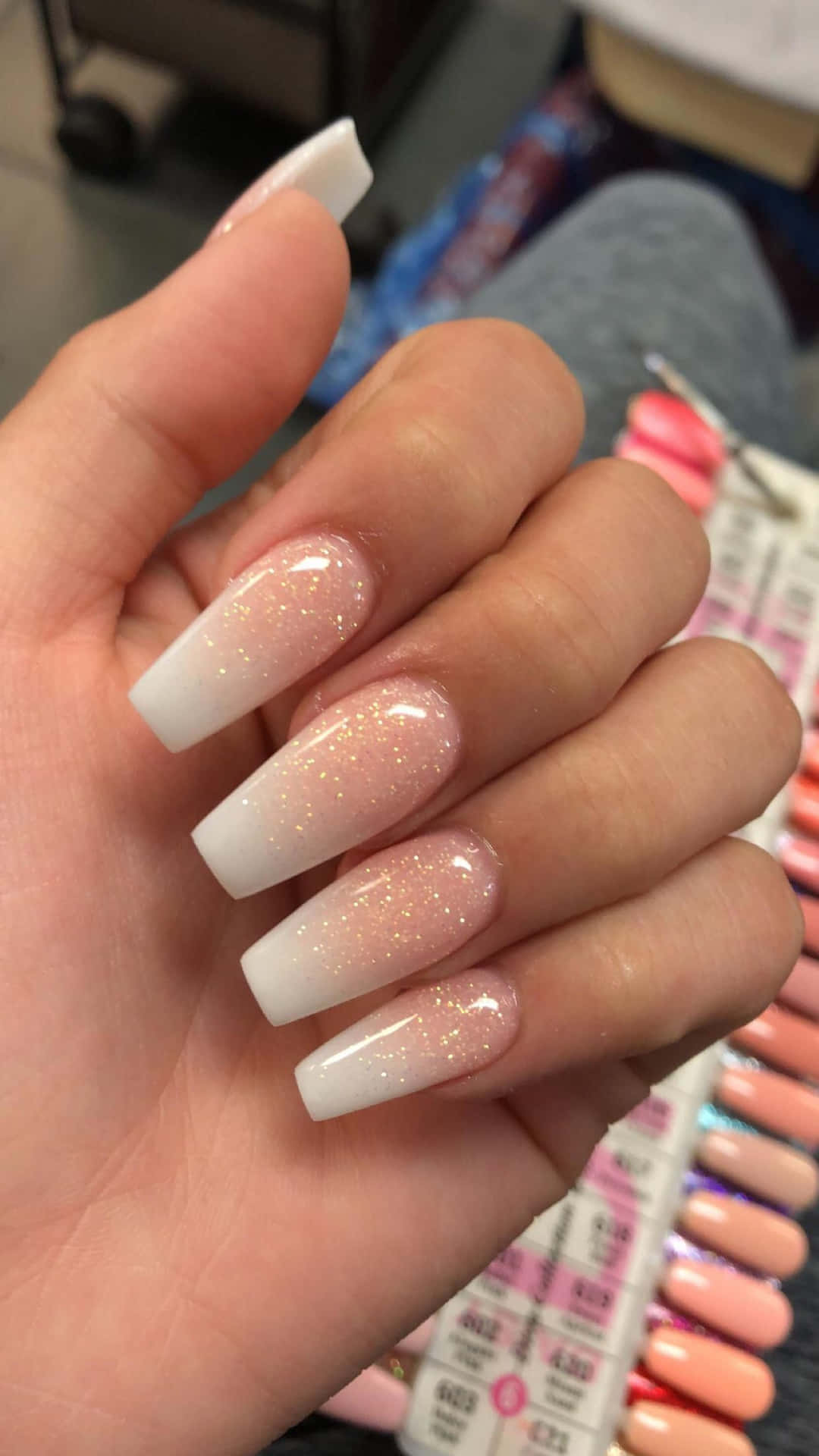 A Woman Holding A Pink And White Nail Polish Background