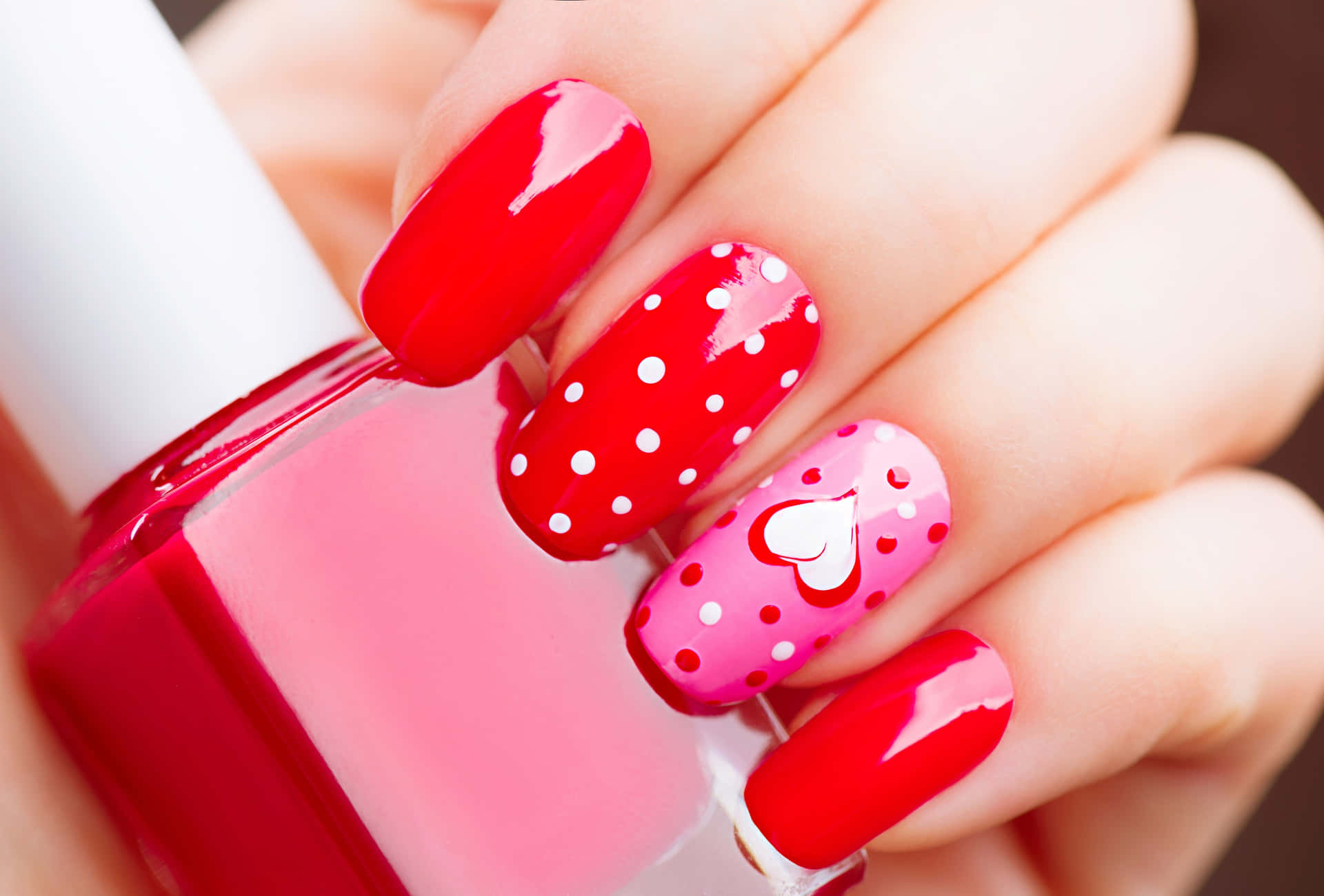 A Woman Holding A Red Nail Polish With Polka Dots Background