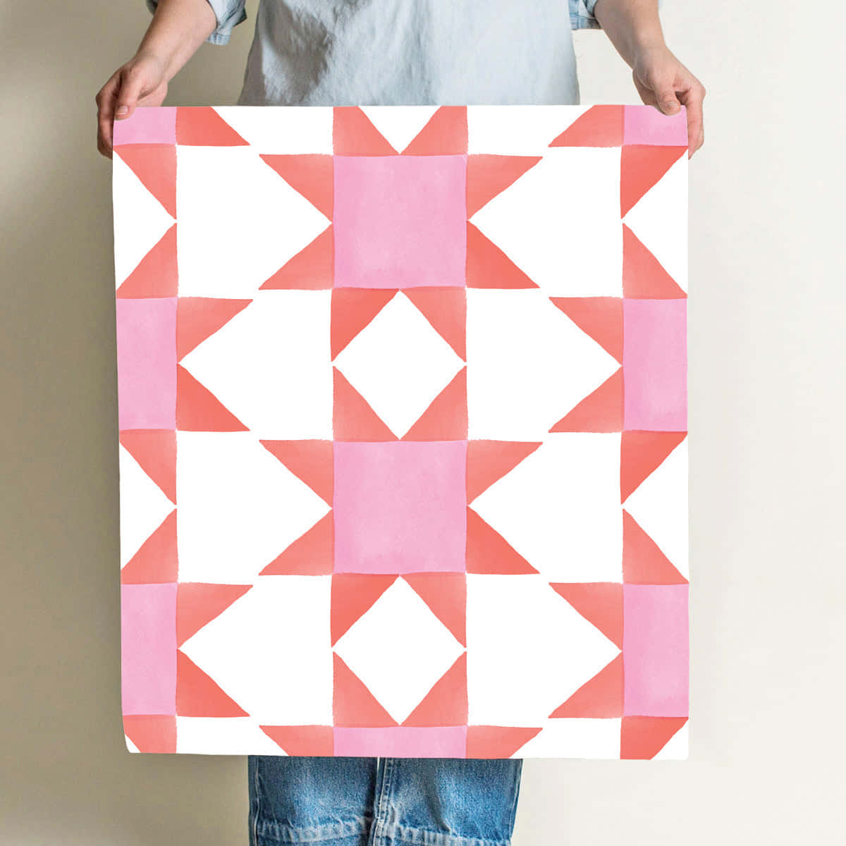A Woman Holding Up A Pink And White Quilt Background