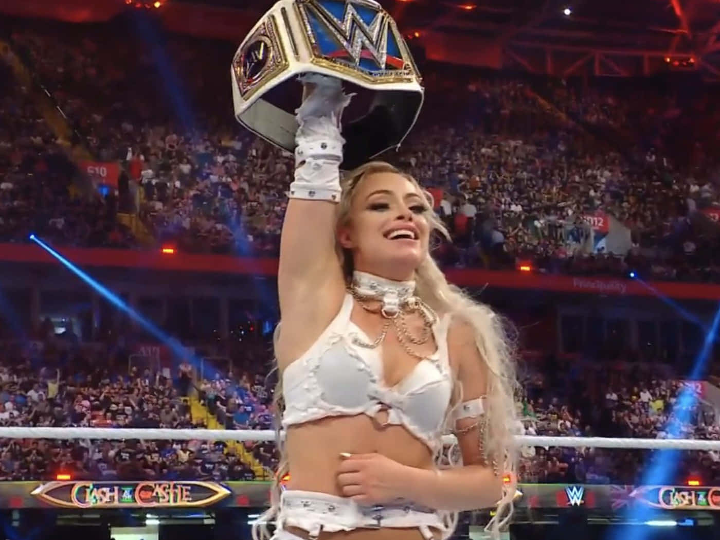 A Woman Holding Up A Wwe Championship Belt Background