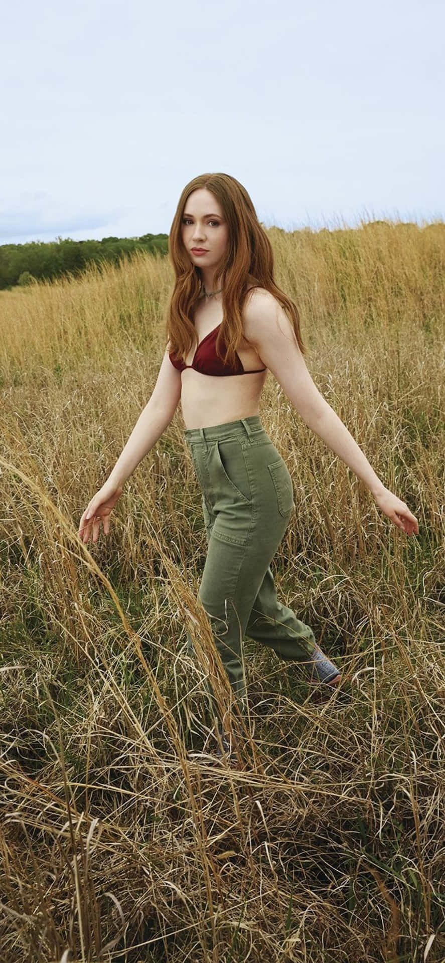 A Woman In A Bikini Standing In A Field Background